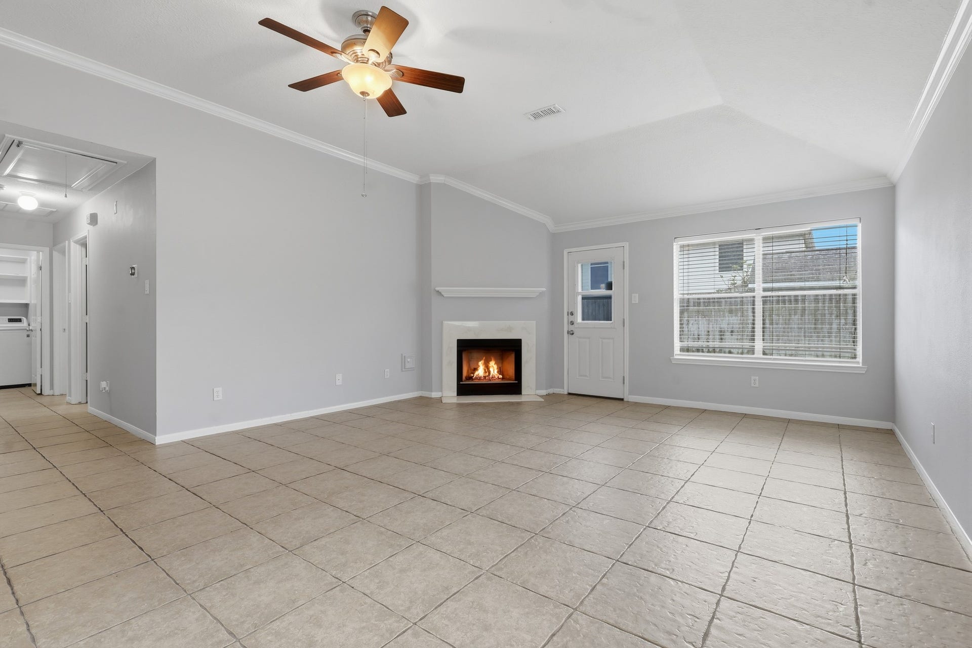 1242 Hunter Wood Drive, League City, TX 77573 Open-concept living space featuring a cozy fireplace and easy-care tile flooring.