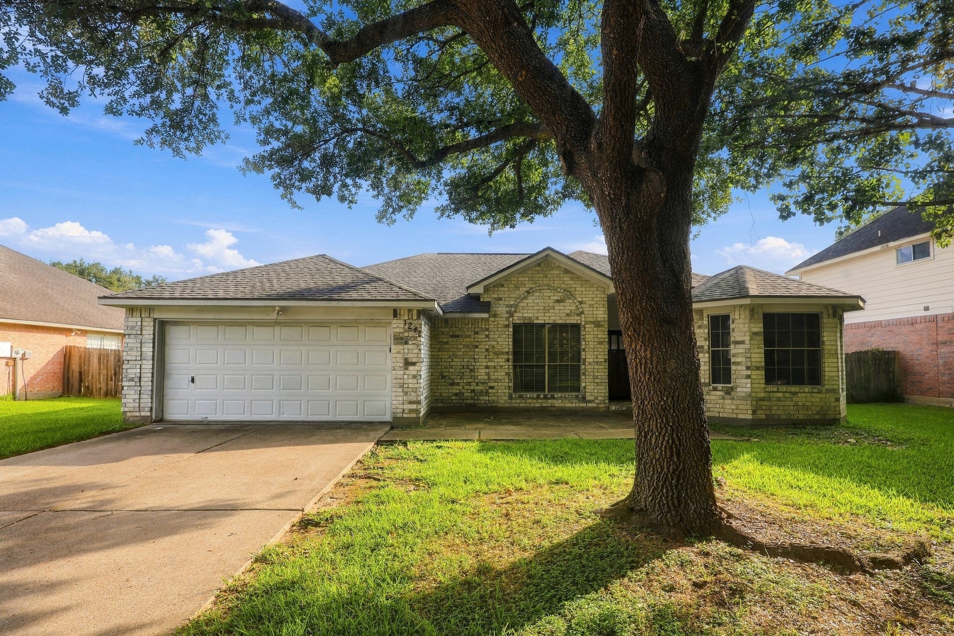 1242 Hunter Wood Drive, League City, TX 77573 Charming one-story home with mature shade tree and welcoming curb appeal.