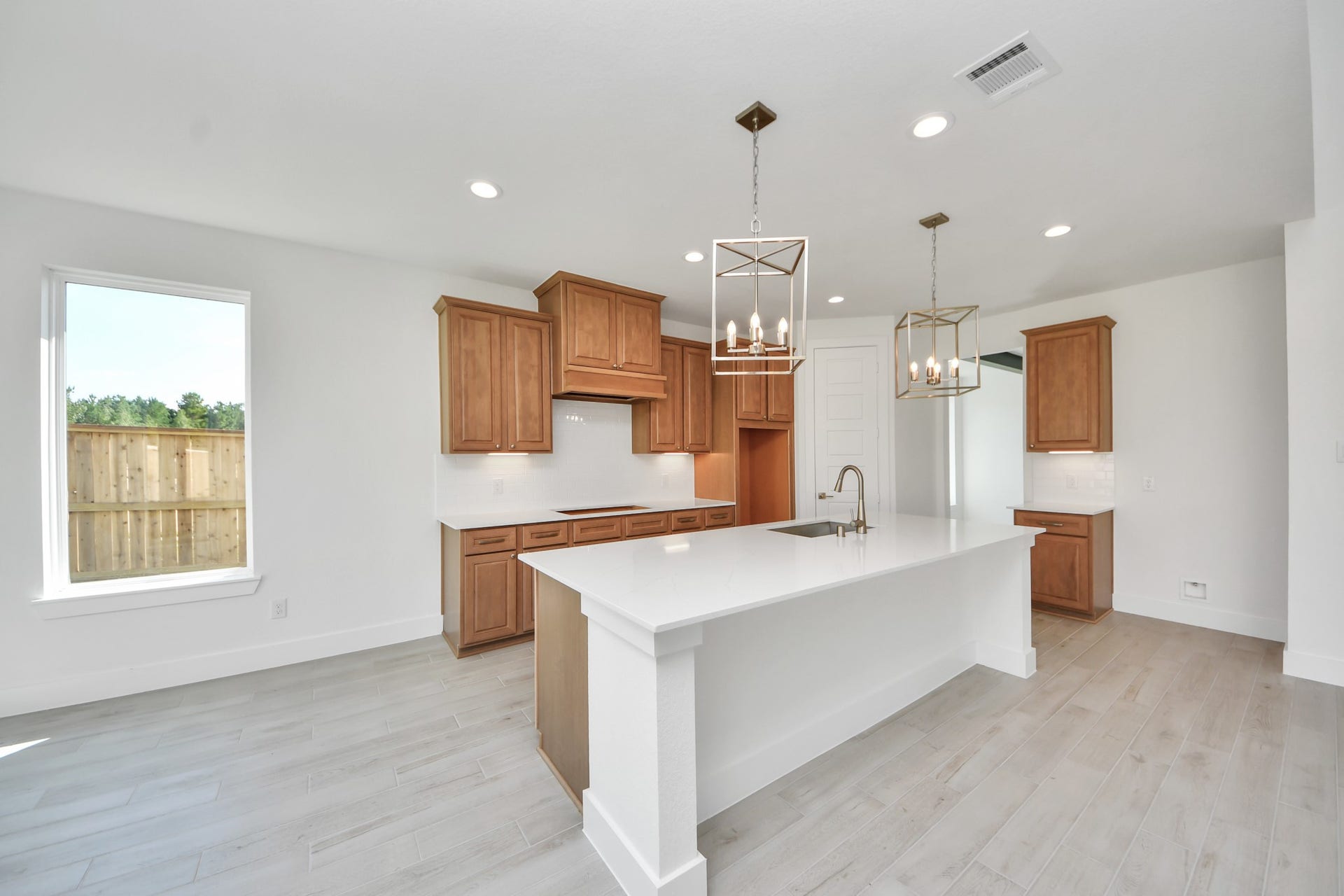 2052 Thimbleberry Lane, Magnolia, TX 77355 This kitchen is truly a chef's dream! This haven Boasts high ceilings, recessed & pendant lighting, stained wood cabinets, granite countertops, stainless steel appliances, a modern tile backsplash. All of this overlooks your expansive family room, creating a perfect space for culinary delights and family gatherings.
