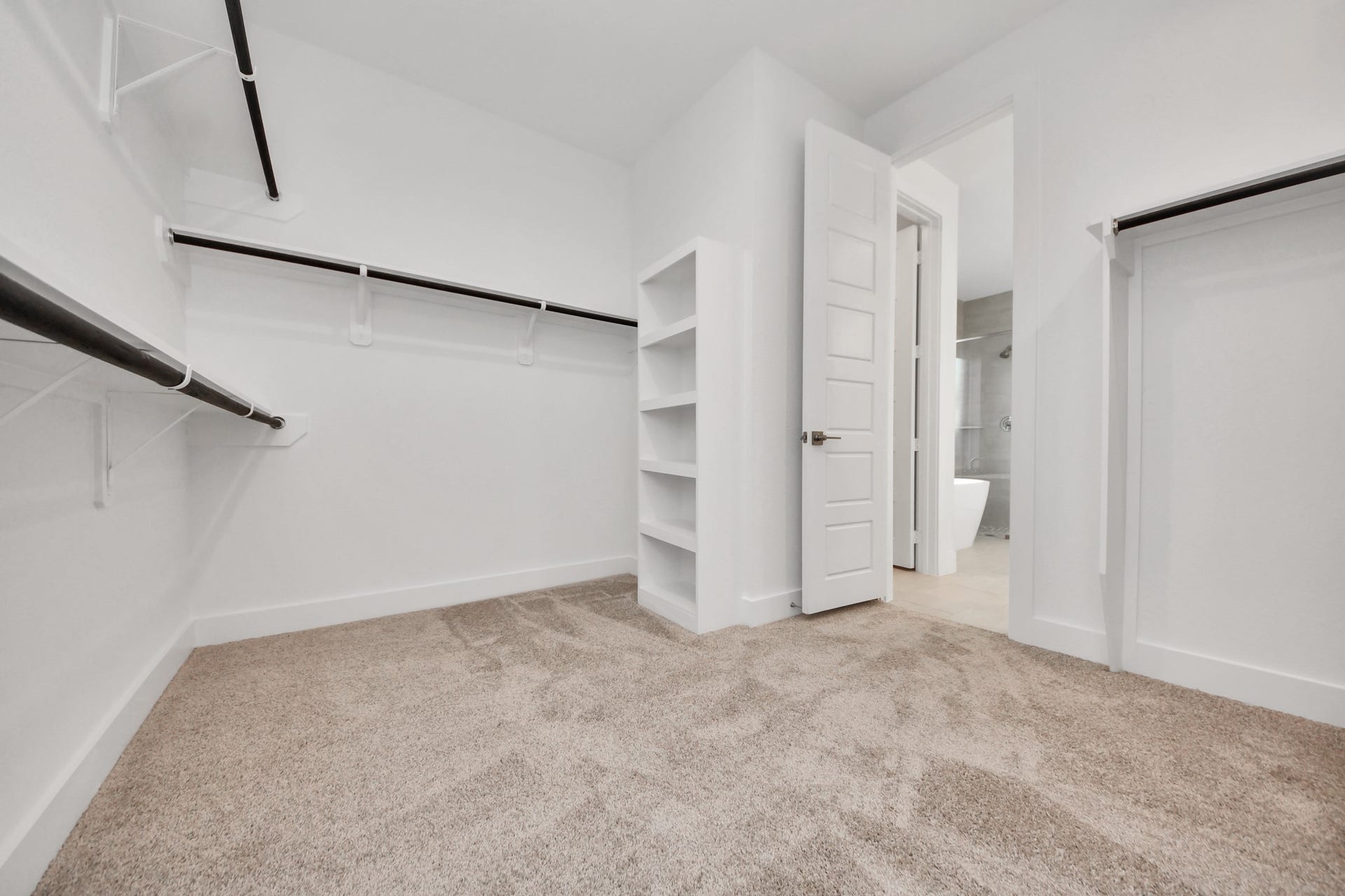 2052 Thimbleberry Lane, Magnolia, TX 77355 Walk-in closet that epitomizes luxury and practicality. This generously sized space features built-in shelving, offering abundant room for impeccable organization. High ceilings and recessed lighting create a bright and welcoming ambiance.