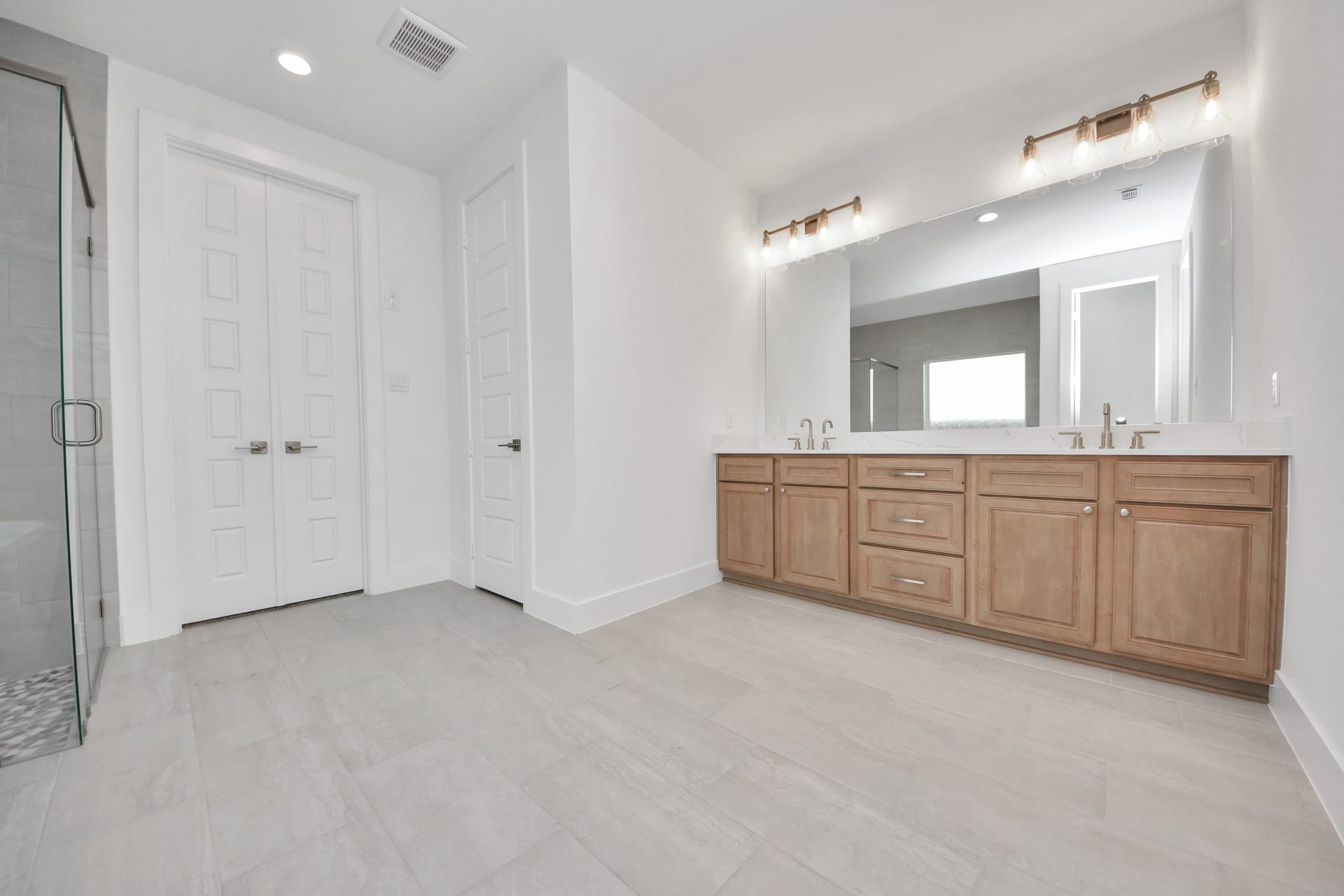 2052 Thimbleberry Lane, Magnolia, TX 77355 Elevate your daily routine at the elegant vanity, now equipped with double sinks, light countertops, modern hardware, and beautiful vanity lights.