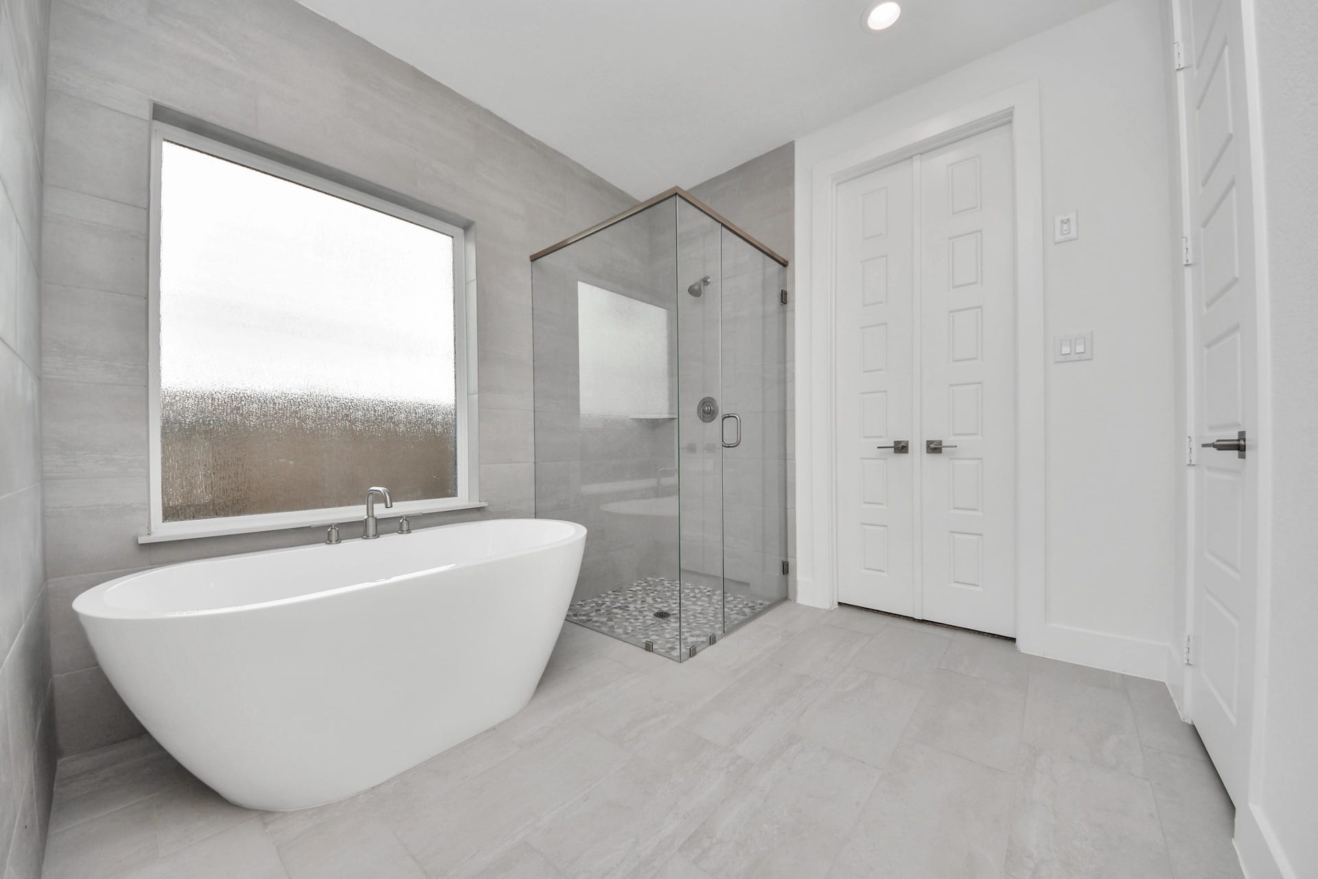 2052 Thimbleberry Lane, Magnolia, TX 77355 Indulge in a spa-like retreat within the confines of this primary bathroom. Delight in a spacious walk-in shower enveloped in stylish tile surround, unwind in a separate garden tub adorned with custom detailing.