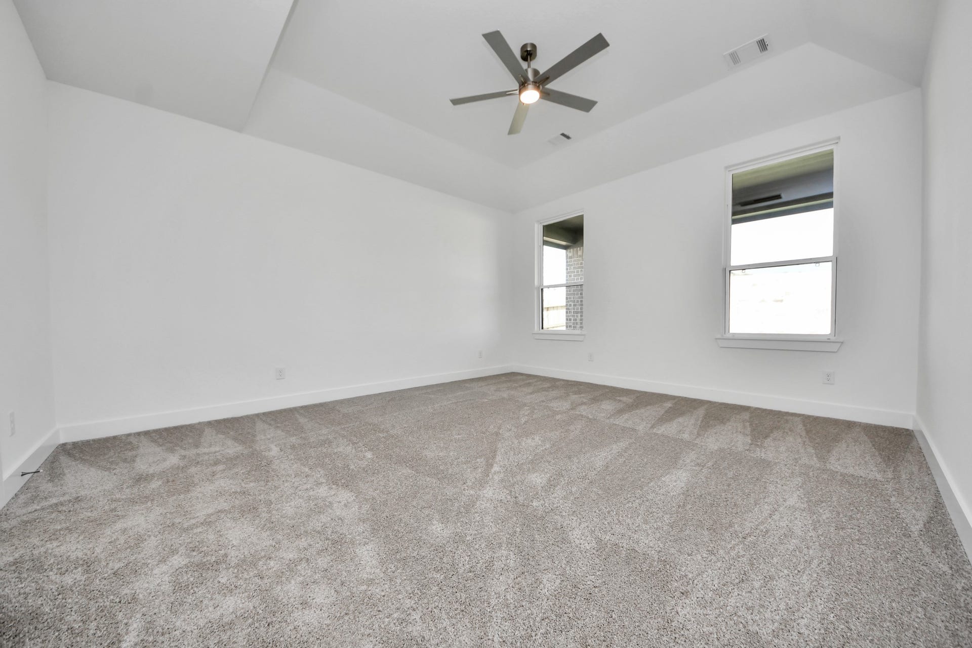 2052 Thimbleberry Lane, Magnolia, TX 77355 Retreat to the luxurious primary suite, your perfect escape for unwinding after a long day. Located on the first floor, this spacious room features plush carpeting, calming paint tones, high ceilings, and large windows with privacy blinds.