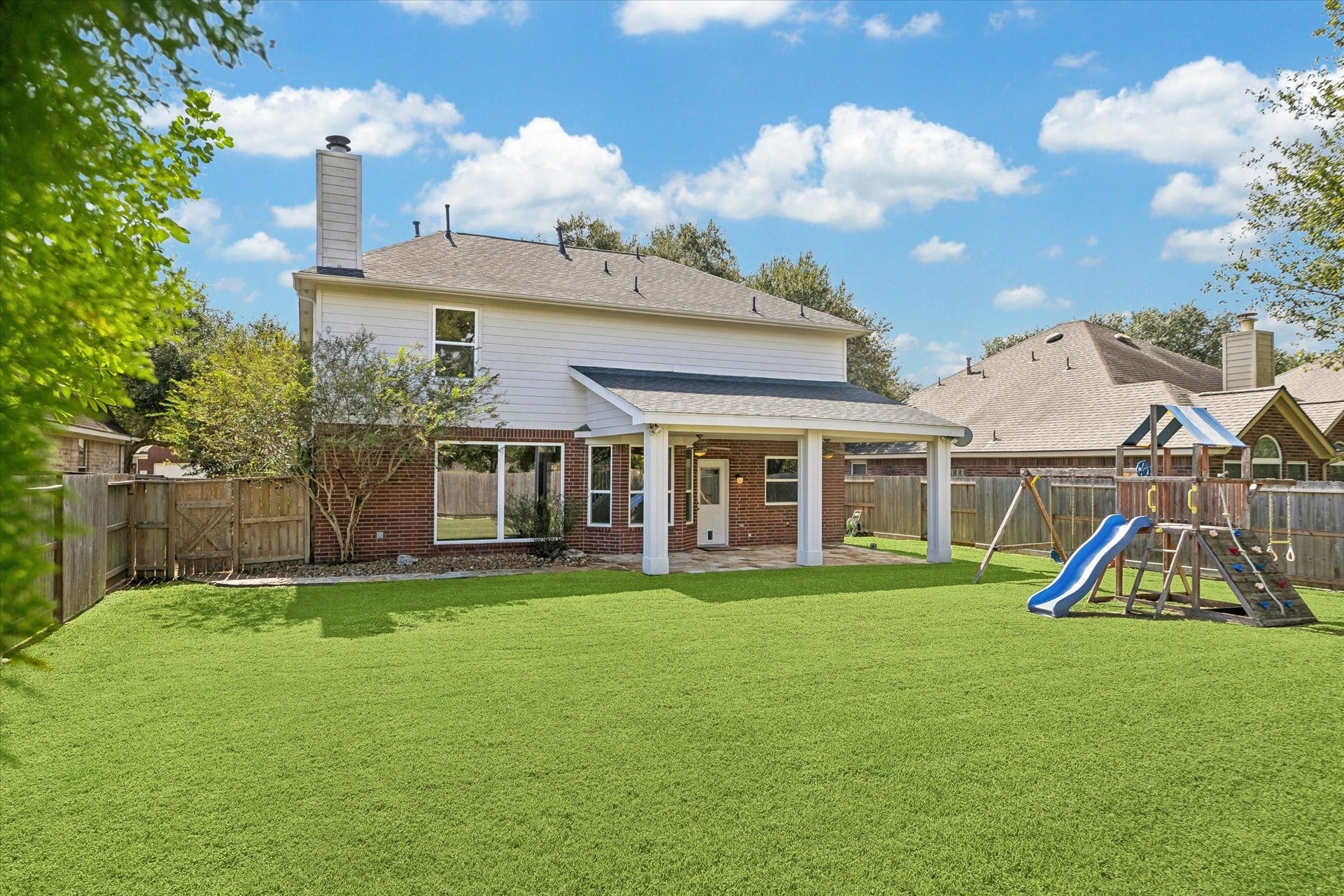 7614 BROKEN OAK LANE, Sugar Land, TX 77479 The rear view showcases the homes TWO-STORY DESIGN and covered patio overlooking a broad lawn.