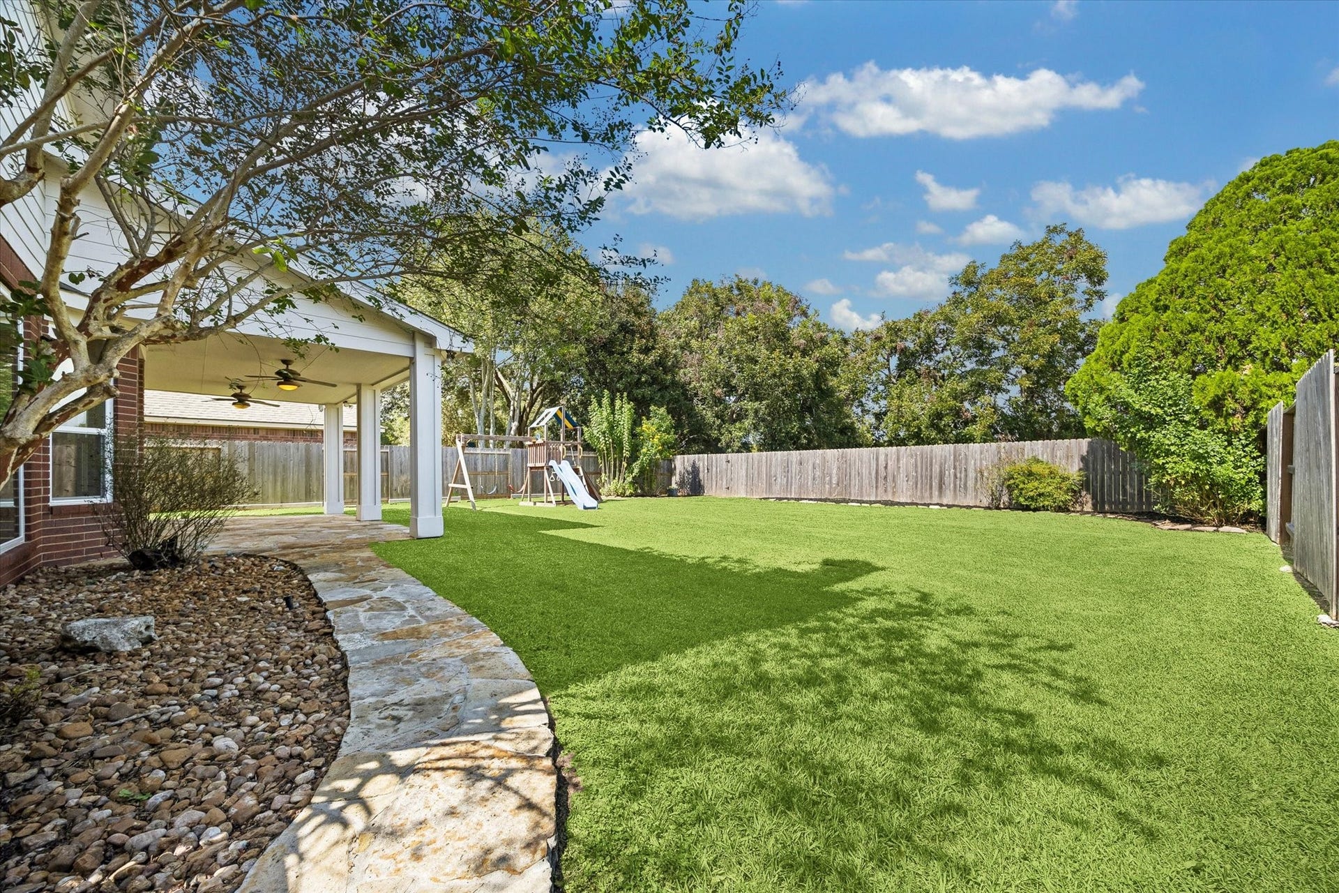7614 BROKEN OAK LANE, Sugar Land, TX 77479 A curved STONE WALKWAY borders the spacious FENCED BACKYARD, with mature trees adding shade and character.