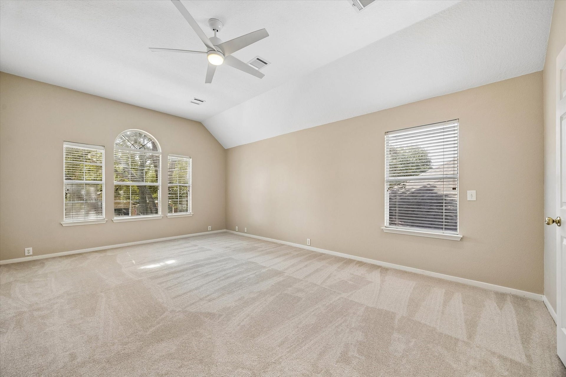 7614 BROKEN OAK LANE, Sugar Land, TX 77479 A HIGH CEILING and distinctive ARCHED WINDOW bring light and character to this spacious primary bedroom.