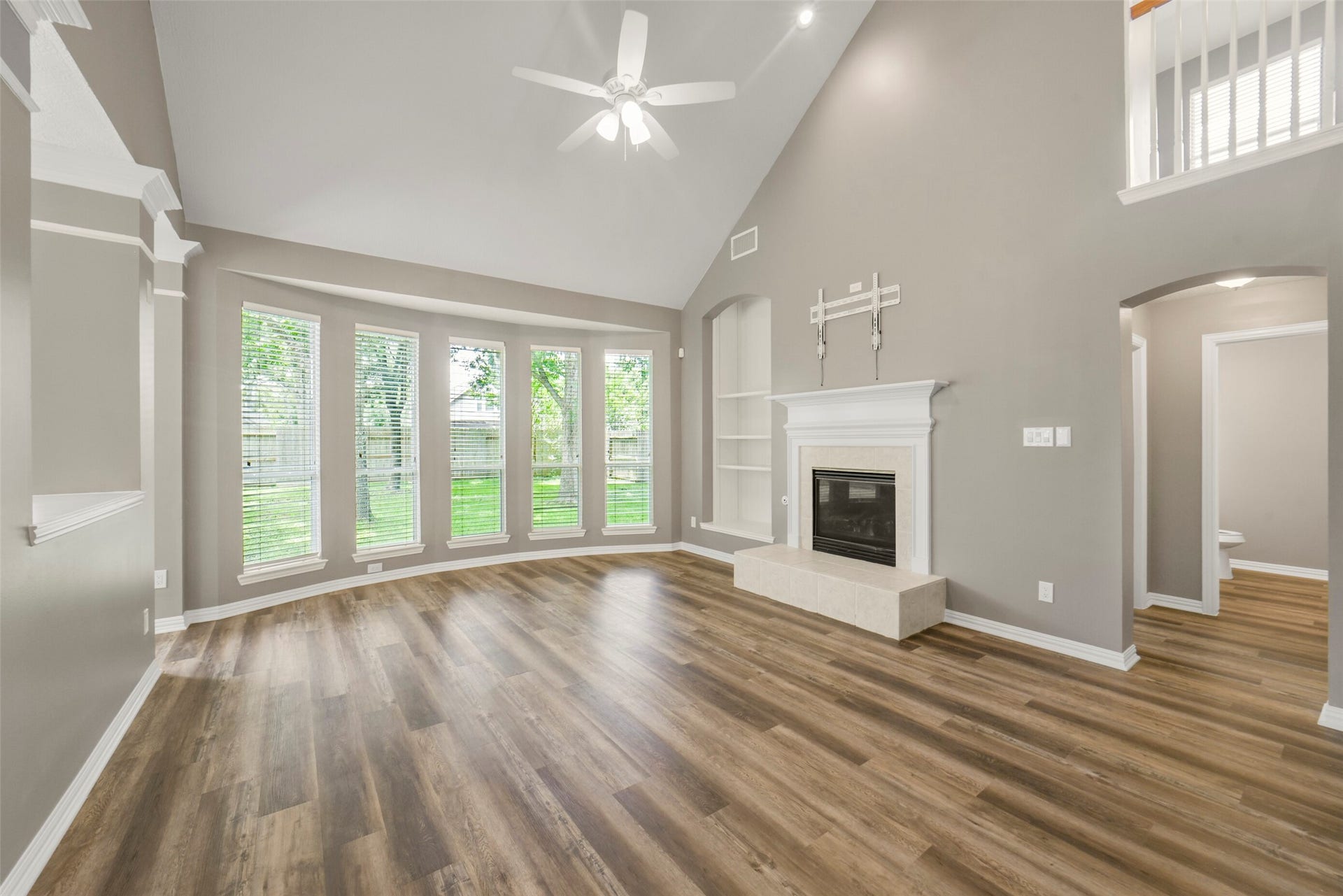 13023 Norstrum Falls Court, Cypress, TX 77429 The breathtaking living room boasts built-in shelving, a fireplace, soaring high ceilings, and massive windows that flood the space with natural light.