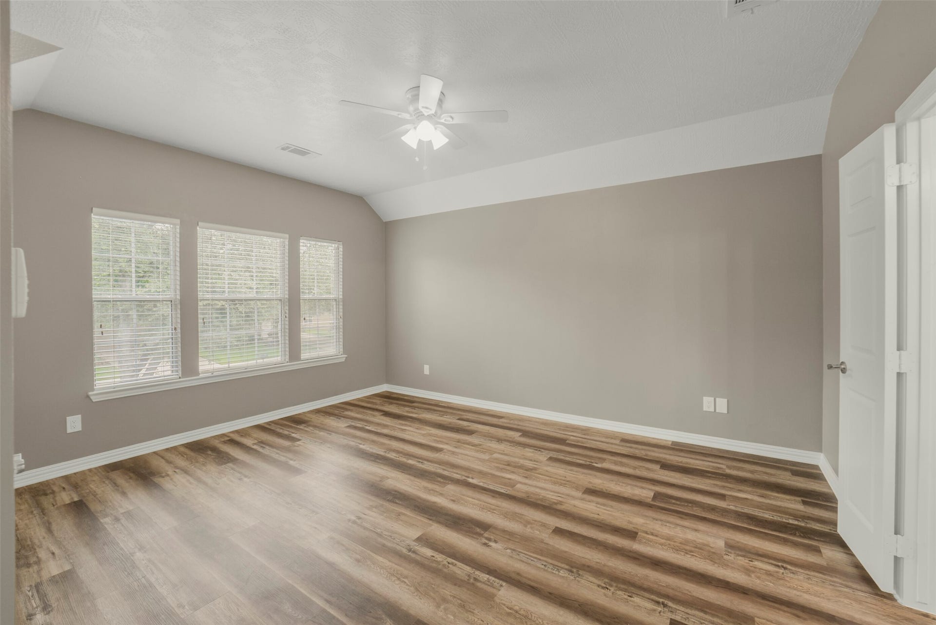 13023 Norstrum Falls Court, Cypress, TX 77429 The expansive primary bedroom serves as a peaceful retreat, highlighted by large windows that fill the room with natural light.