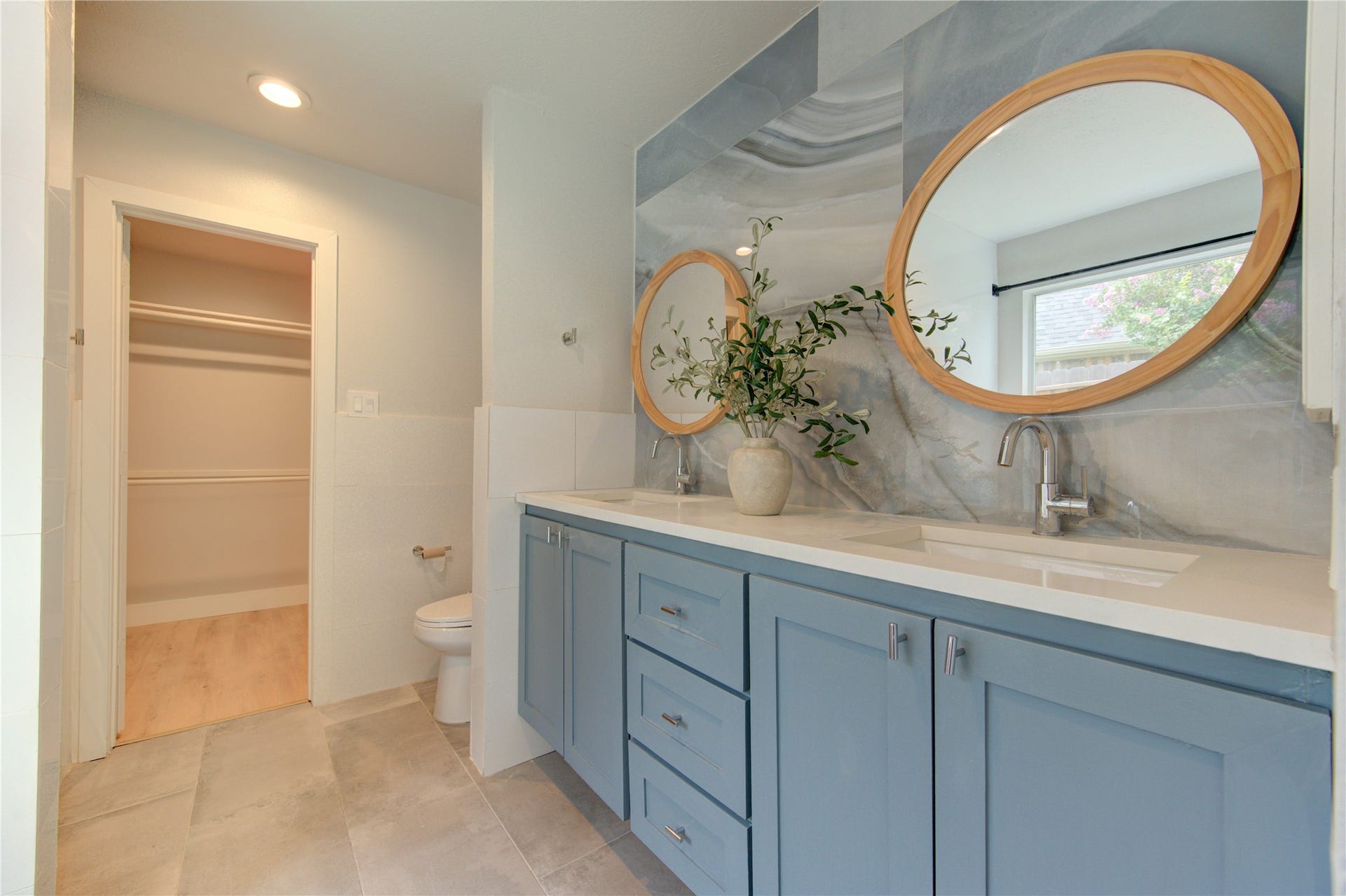 4931 Lake Catherine Court, Richmond, TX 77407 Stylish dual vanities with quartz countertops, modern cabinetry, round framed mirrors and striking designer tile create a luxurious everyday experience