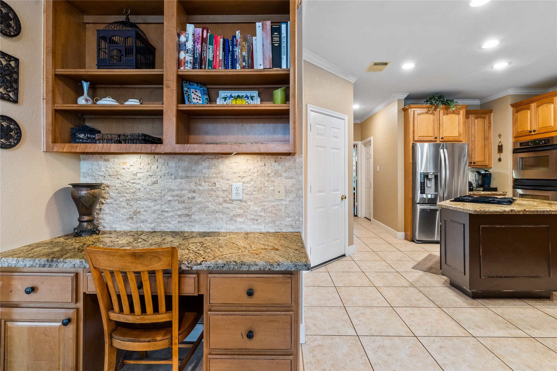 7914 Chianti Court, Sugar Land, TX 77479 Convenient built-in workspace features granite countertops, upper shelving, and ample storageideal for a home office or study nook.