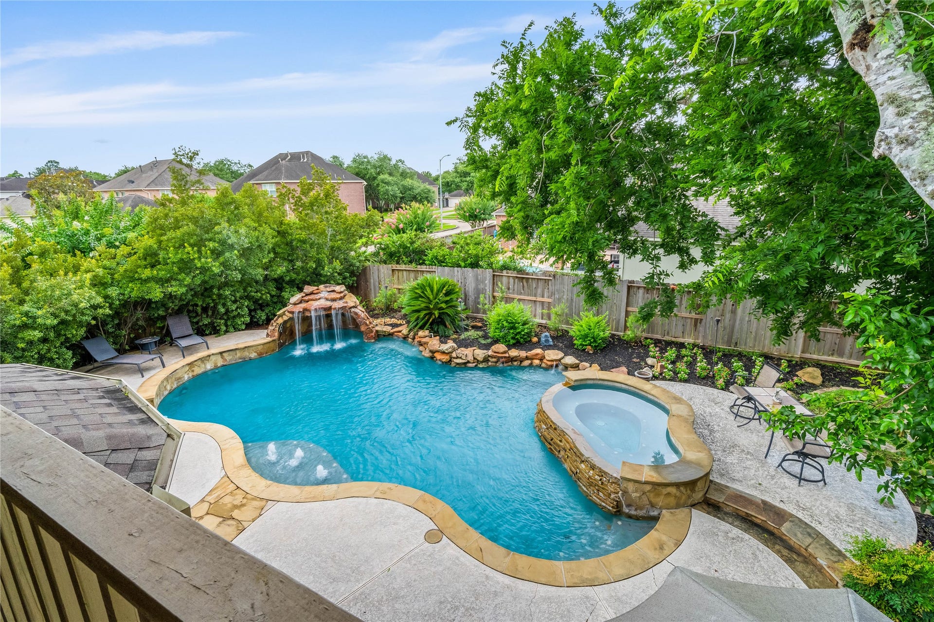 7914 Chianti Court, Sugar Land, TX 77479 Elevated view showcases a resort-style pool with rock waterfall, spa, and surrounding landscaping.