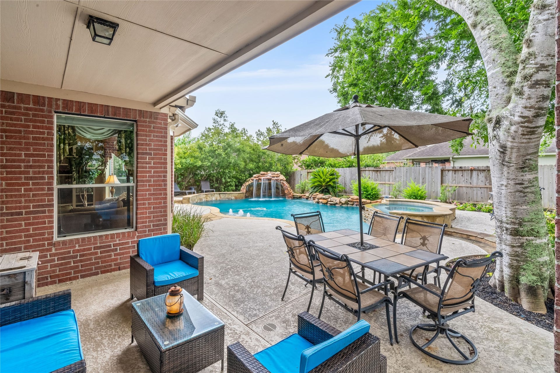 7914 Chianti Court, Sugar Land, TX 77479 Inviting outdoor living area overlooks the pool, spa, and waterfall feature, creating a relaxing backyard setting.