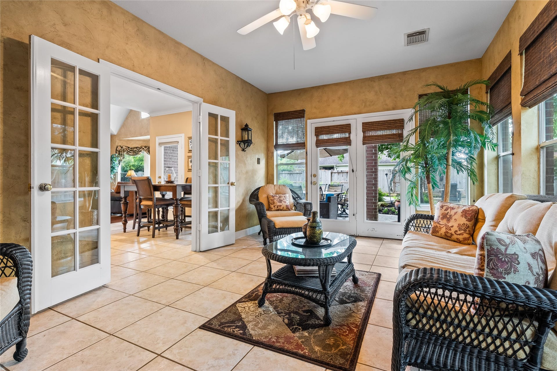 7914 Chianti Court, Sugar Land, TX 77479 Light-filled sunroom with tile flooring and French doors offers a versatile space for relaxing, entertaining, or a secondary living area with direct patio access.