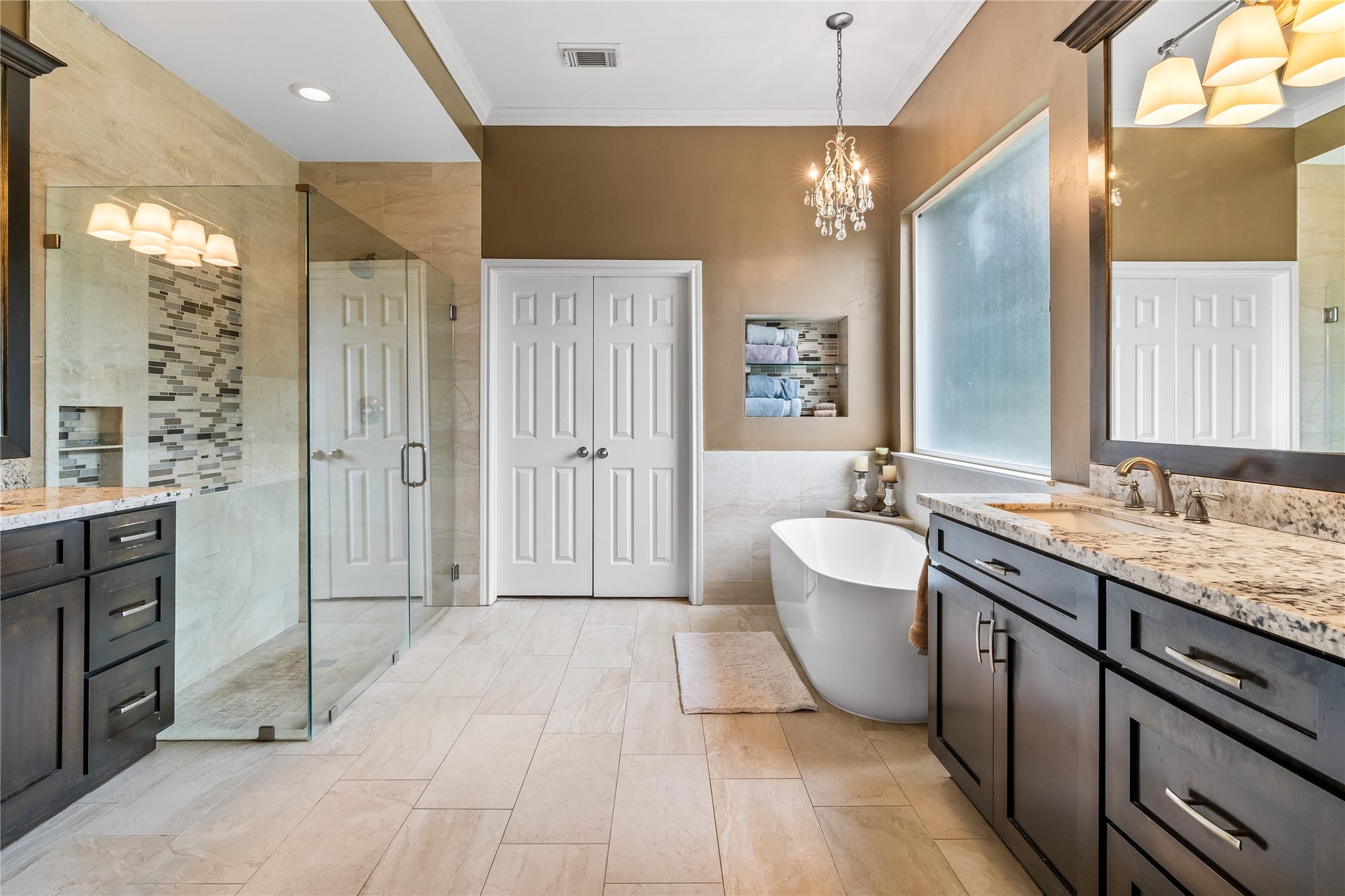 7914 Chianti Court, Sugar Land, TX 77479 Spa-like primary bath, remodeled in 2017, includes dual vanities with granite countertops, a freestanding soaking tub, and a large walk-in shower with glass enclosure.
