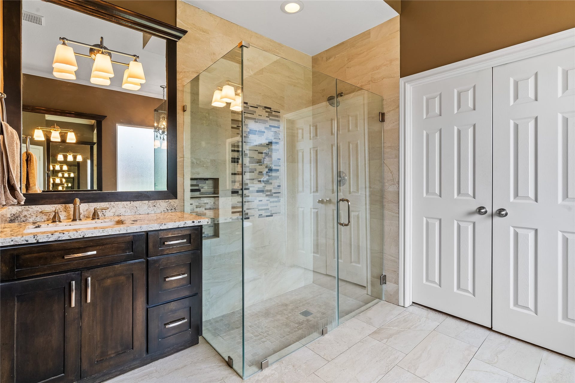 7914 Chianti Court, Sugar Land, TX 77479 Oversized walk-in shower features custom tile work, built-in niche, and seamless glass surround for a modern, clean look.