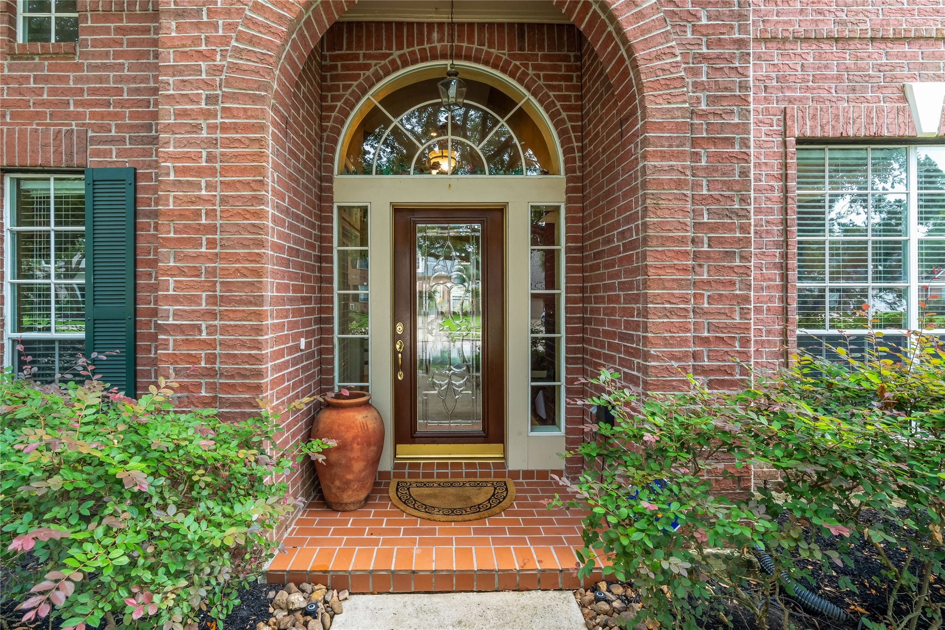 7914 Chianti Court, Sugar Land, TX 77479 Inviting front entry with arched brick detail, decorative glass door, and sidelights creates a warm and welcoming first impression.