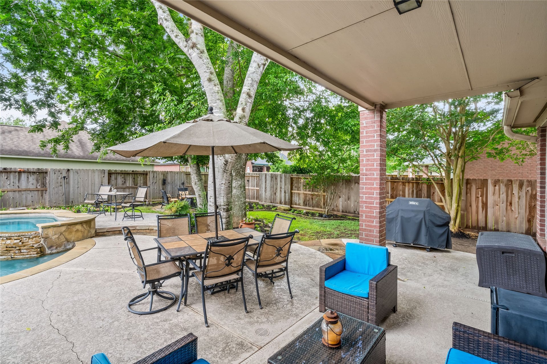 7914 Chianti Court, Sugar Land, TX 77479 Covered patio provides a shaded outdoor dining space with views of the pool and landscaped yard, ideal for entertaining.