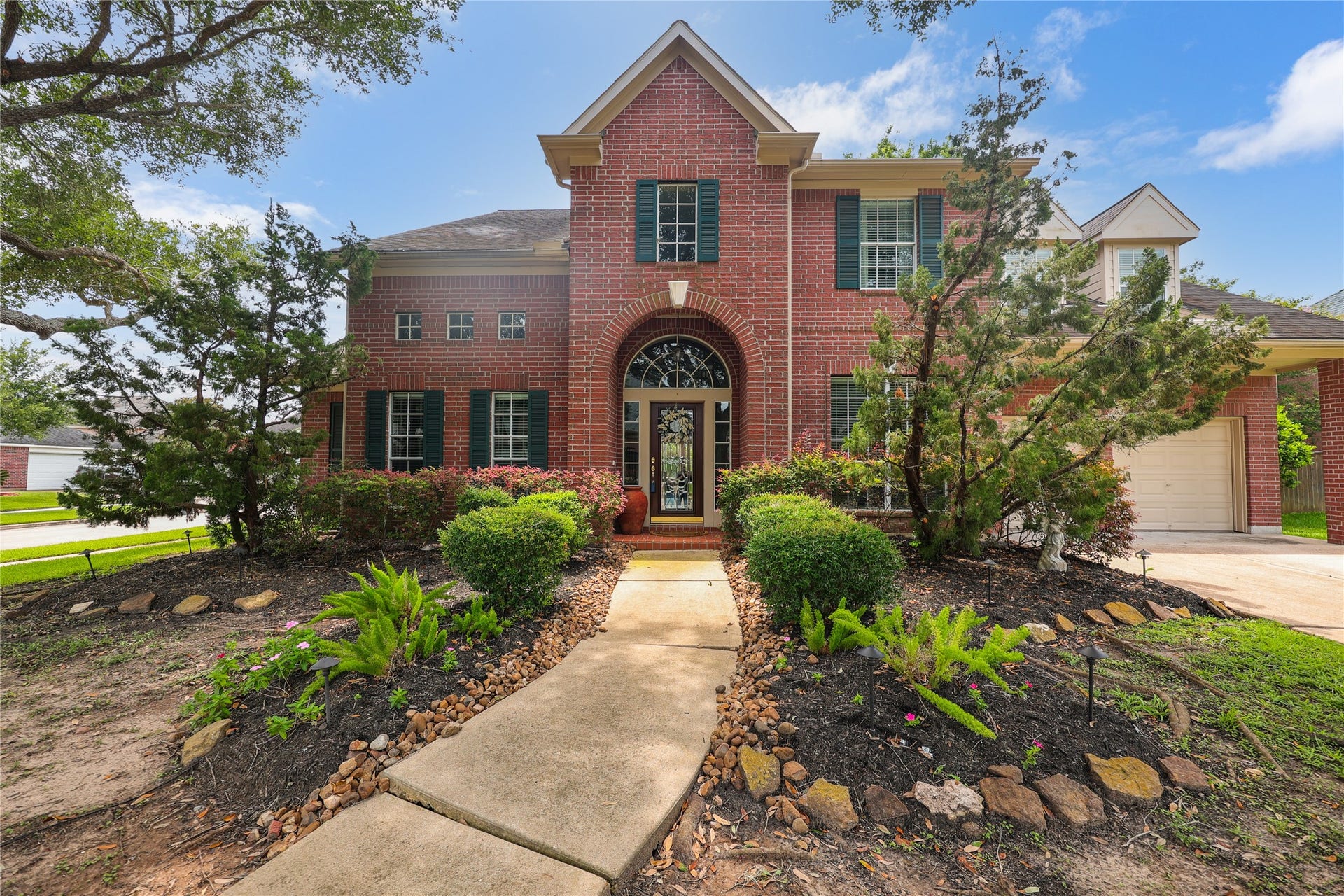 7914 Chianti Court, Sugar Land, TX 77479 Classic brick exterior with manicured landscaping and a curved walkway leading to the front door, framed by mature trees.