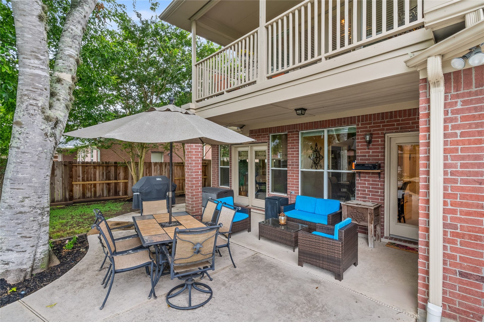 7914 Chianti Court, Sugar Land, TX 77479 Spacious covered patio with ceiling lighting offers a comfortable outdoor living space, complete with seating area and dining setupideal for relaxing or entertaining year-round.