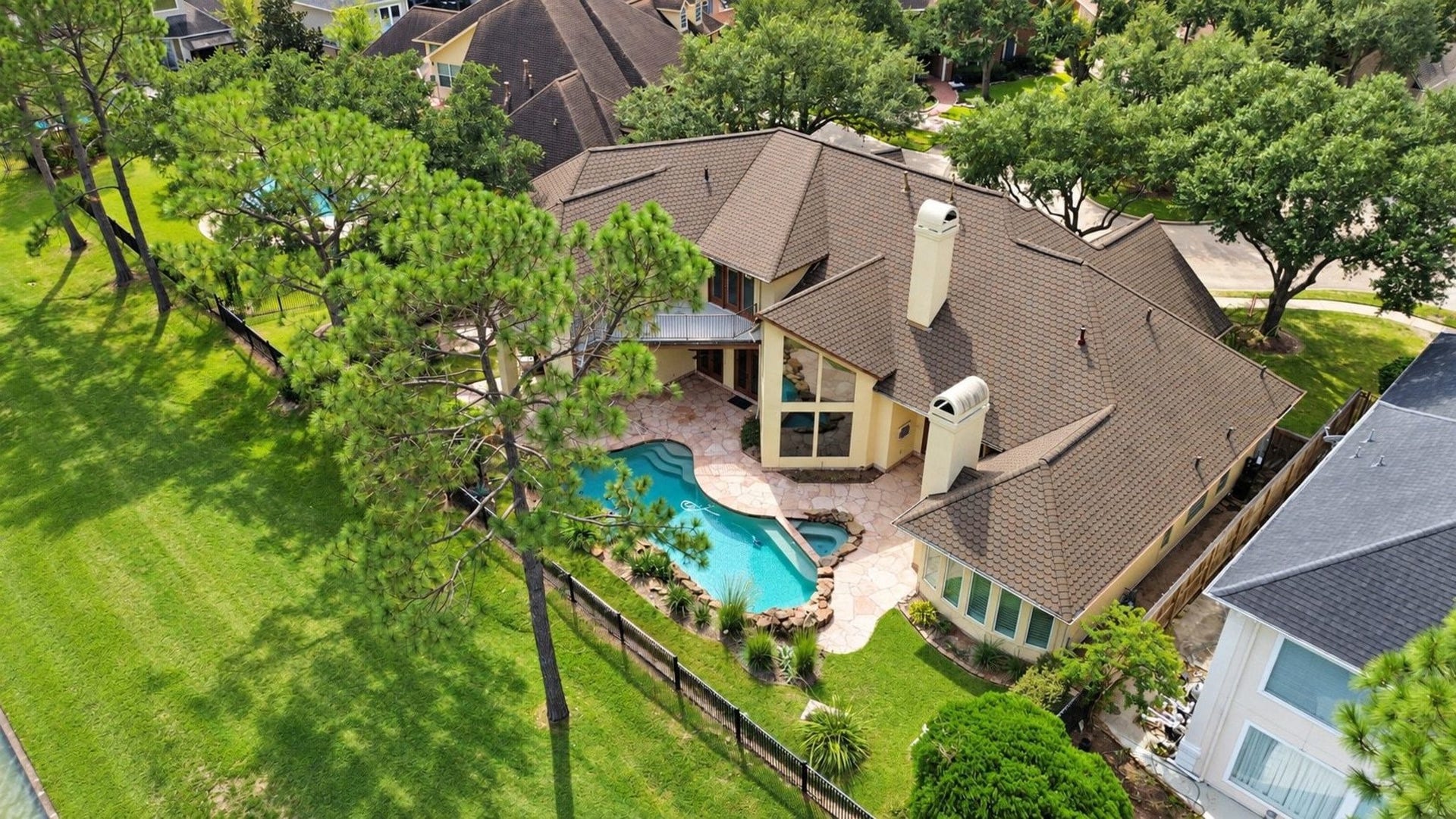 5206 Cedar Bend Creek, Houston, TX 77041 This stunning aerial view highlights the expansive and meticulously manicured backyard, showcasing a perfect balance of lush green lawn and mature, professionally curated landscaping that provides both beauty and privacy!