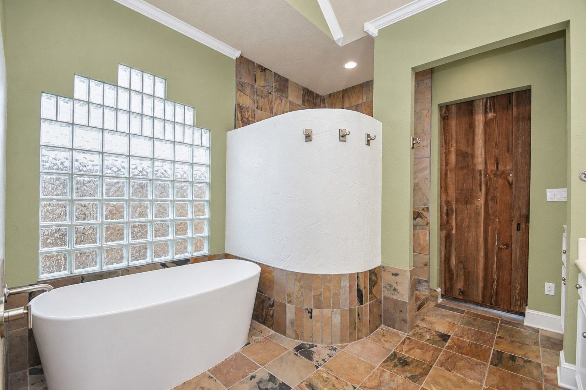5206 Cedar Bend Creek, Houston, TX 77041 This luxurious primary bathroom offers a serene retreat, highlighting a spacious layout anchored by a large soaking tub and a sleek, custom walk-in shower. The room is further elevated by sophisticated vanity finishes, premium hardware, and ample counter space, all perfectly illuminated to create a bright, inviting atmosphere that emphasizes the home's high-end, spa-inspired design.
