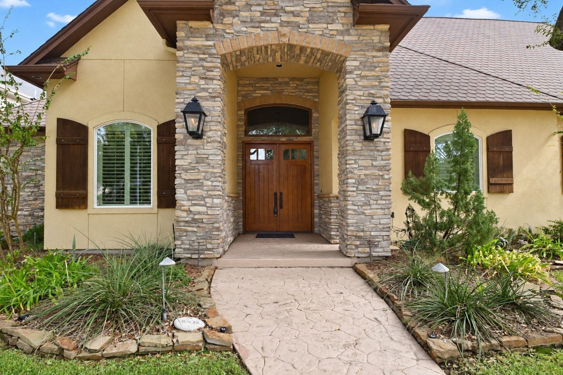 5206 Cedar Bend Creek, Houston, TX 77041 Beautiful stone entrance with custom iron detailing and professional landscape lighting. This grand foyer sets an elegant tone for the entire home, showcasing meticulous craftsmanship and timeless architectural appeal!