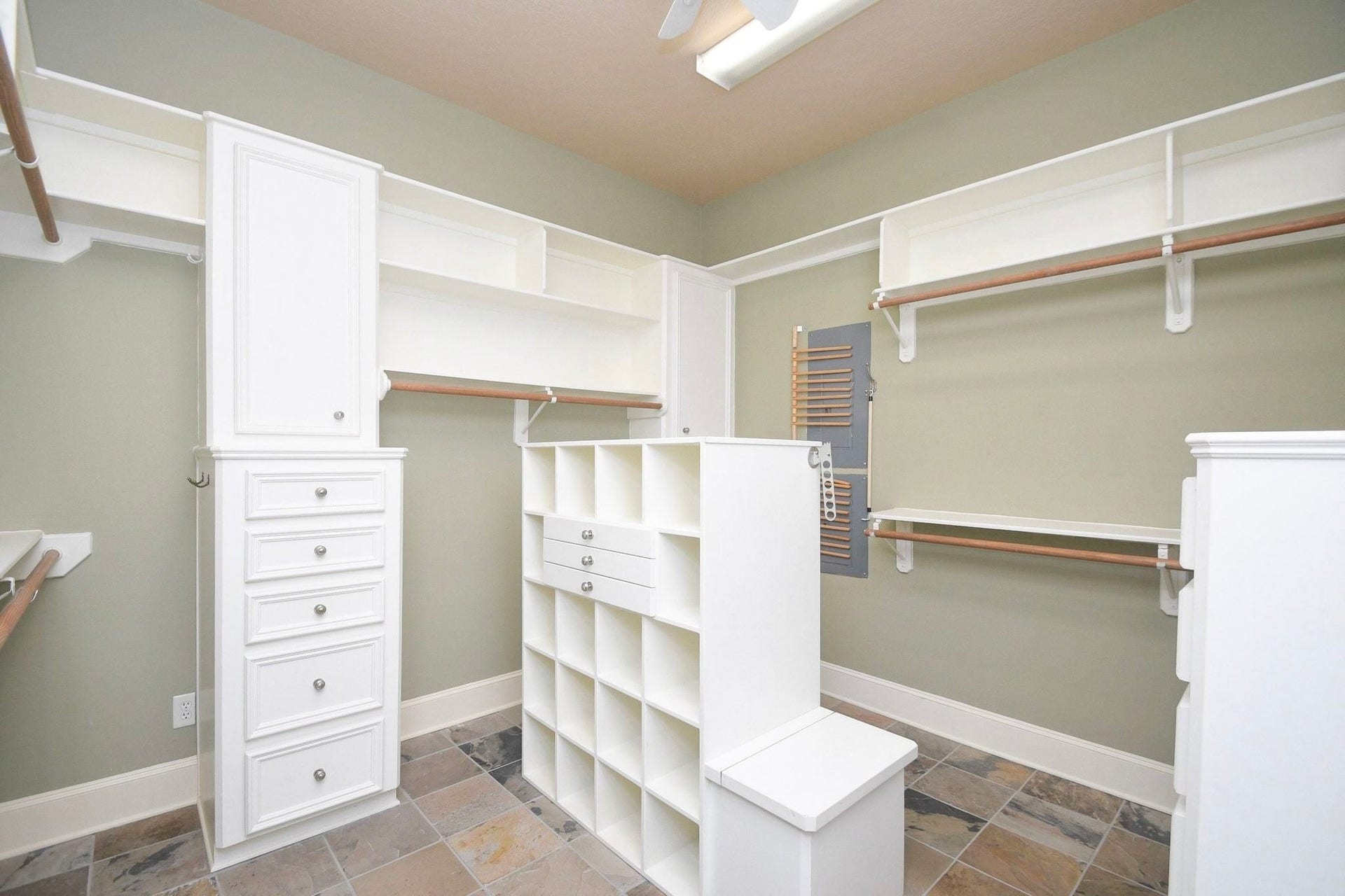 5206 Cedar Bend Creek, Houston, TX 77041 professionally designed walk-in closet that serves as a standout feature of the home. The space is meticulously outfitted with custom-built wooden shelving, integrated organizers, and specialized storage solutions, providing an exceptional level of organization and luxury that maximizes every square inch of the room!