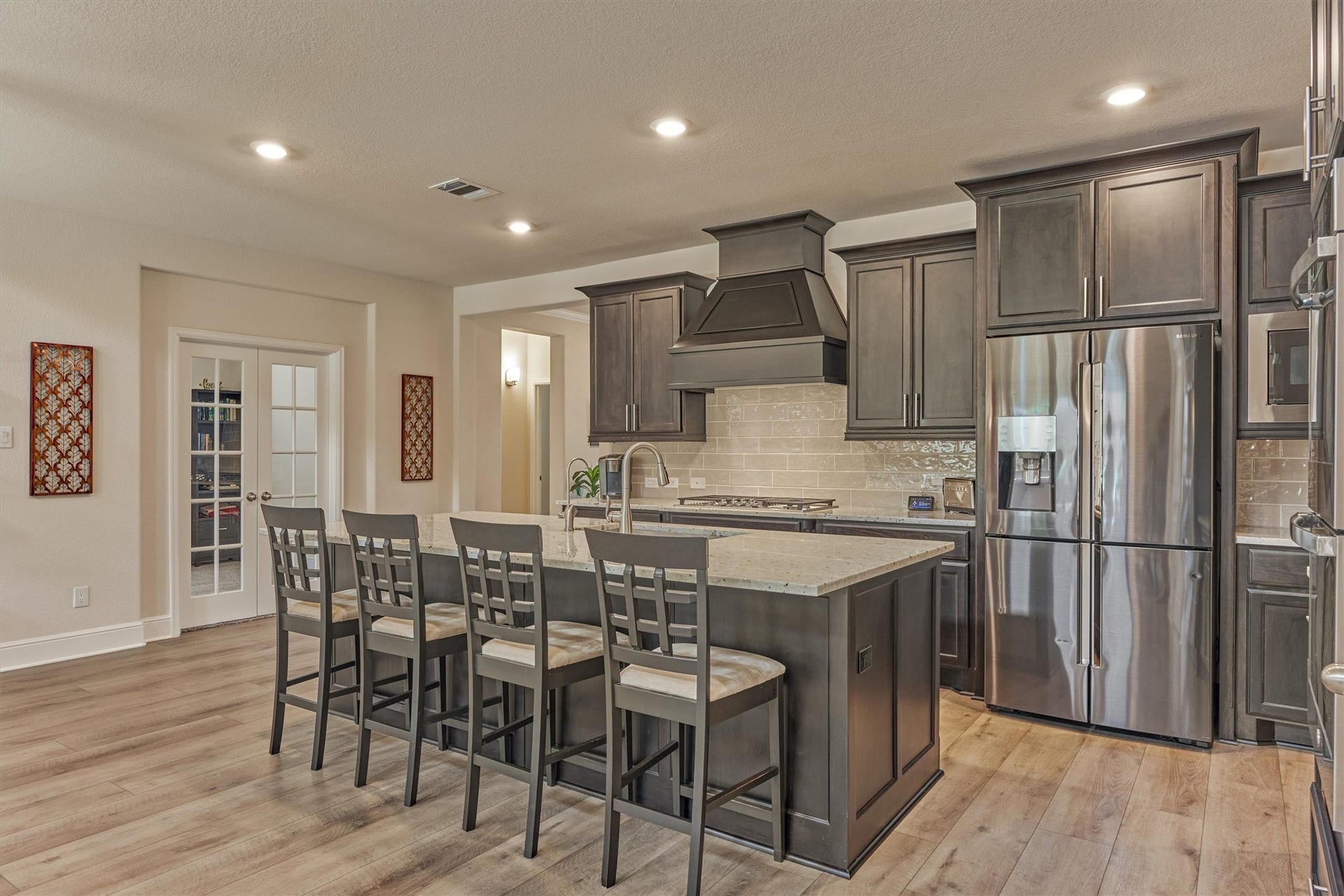 The island kitchen has double ovens and a five-burner gas cooktop.