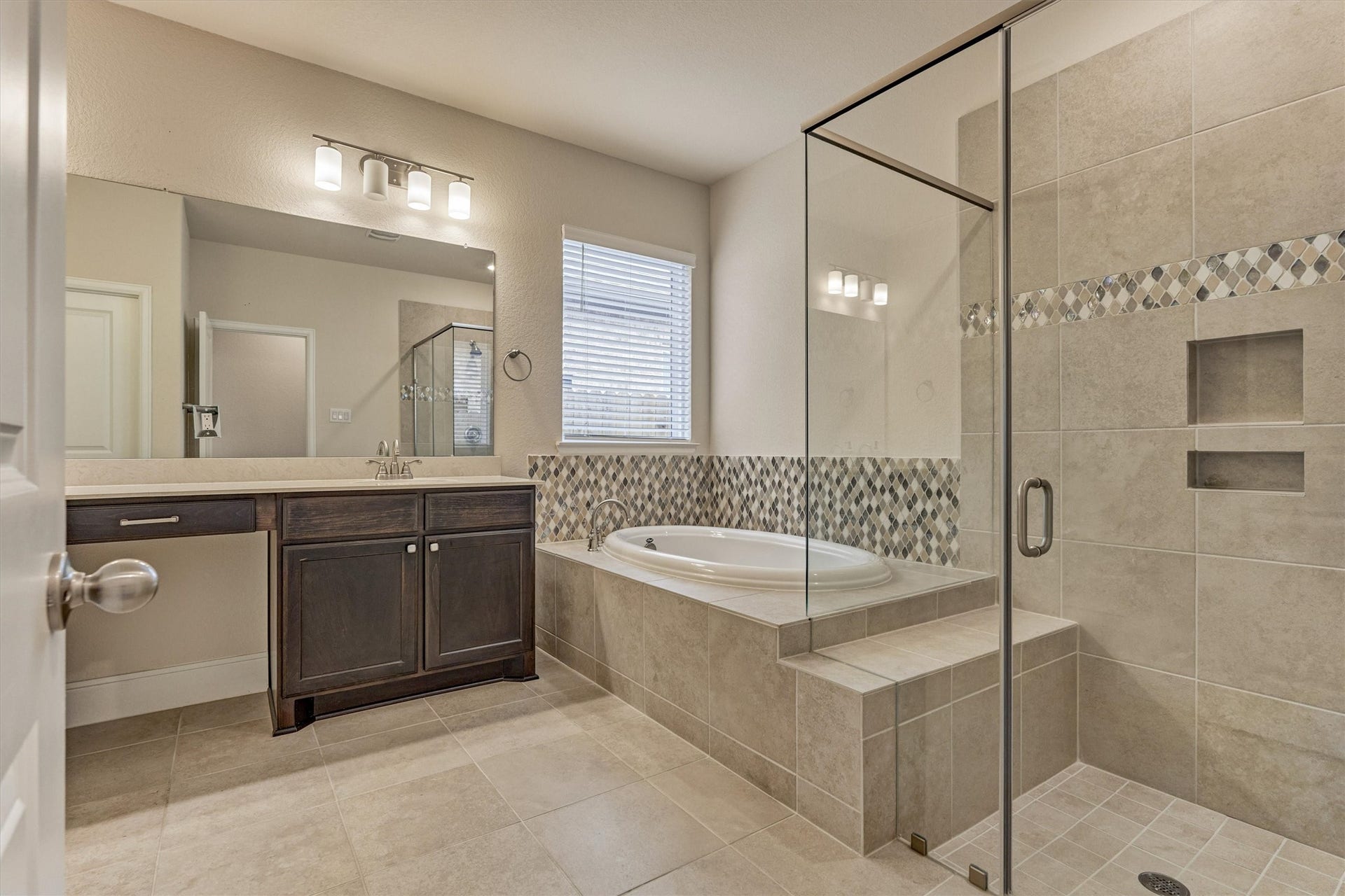 The main bathroom has a large shower with a bench, soaking tub, vanity, and double sinks.