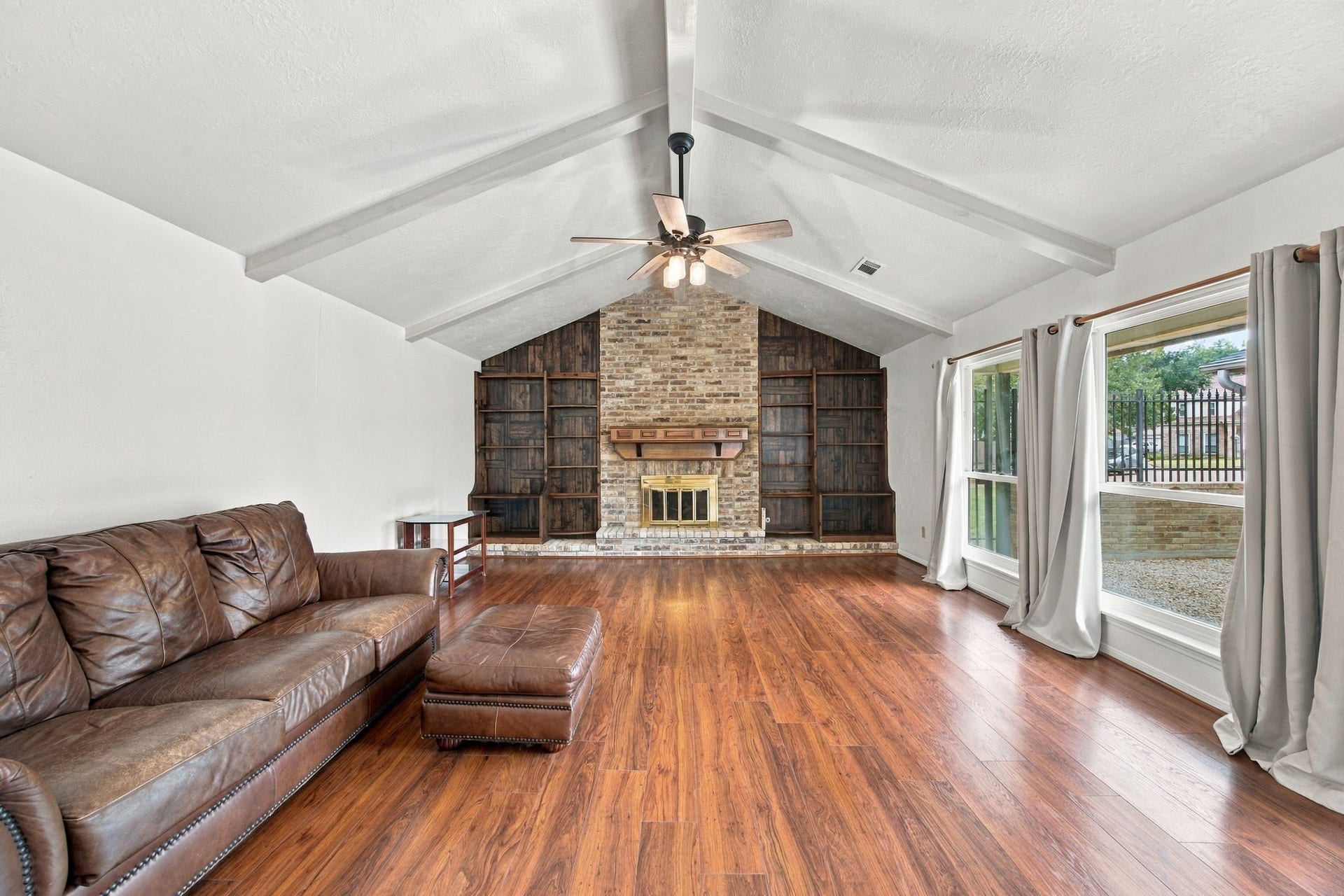 8902 Rocky Lane, Houston, TX 77040 Extra-large living room with vaulted ceilings and built in bookshelves. These windows are Anderson replacement windows.