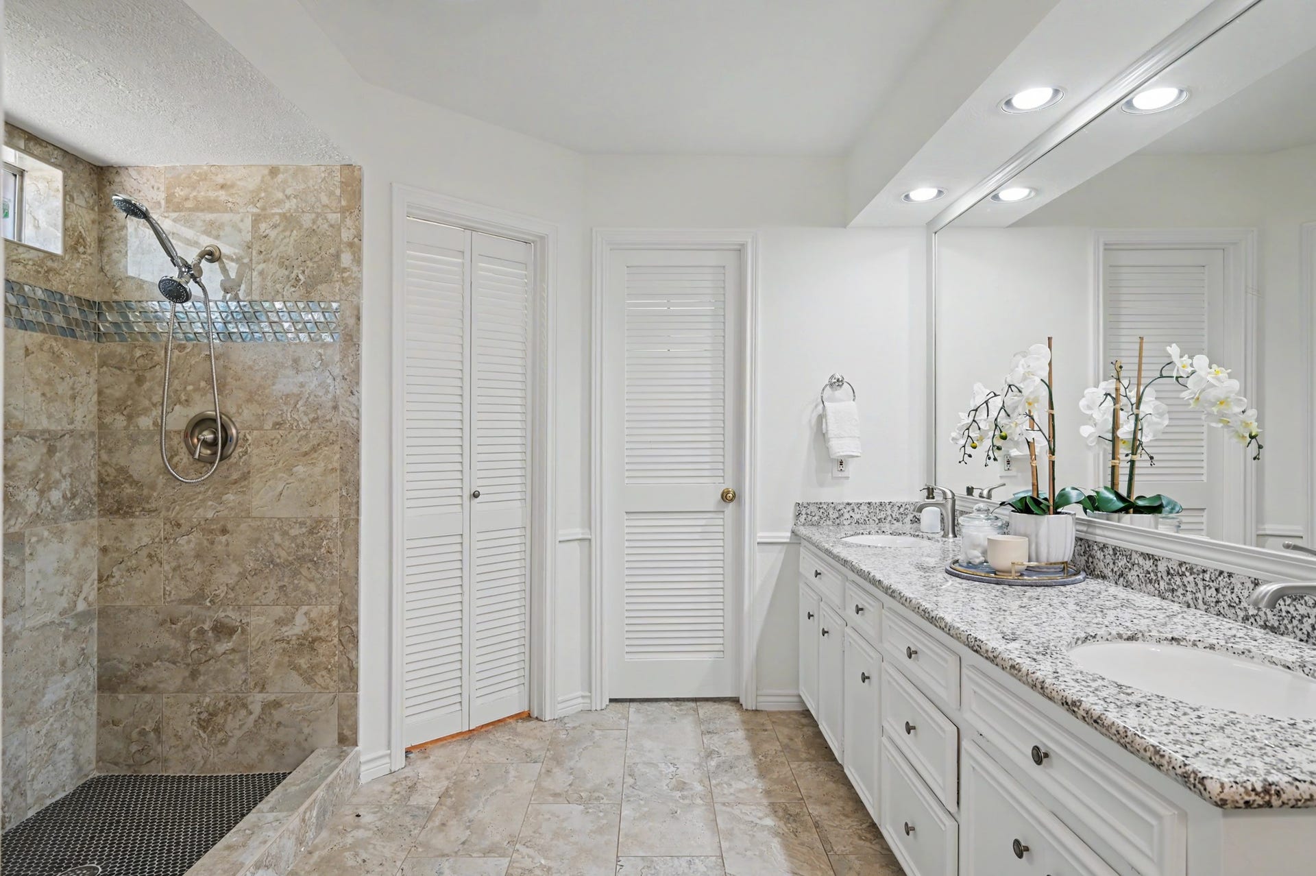 19 Postvine Court, The Woodlands, TX 77381 Primary bedroom en-suite bath features 2 sinks, granite countertops, spacious walk-in shower with elegant tile work & 2 walk-in closets.