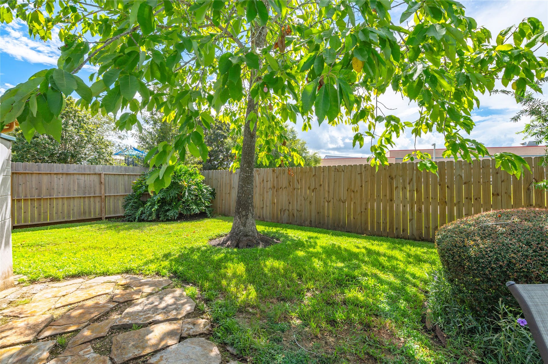 113 Coral Bay Drive, League City, TX 77573 Lots of green space with a full sprinkler system, and a flagstone path leads to the back gate.