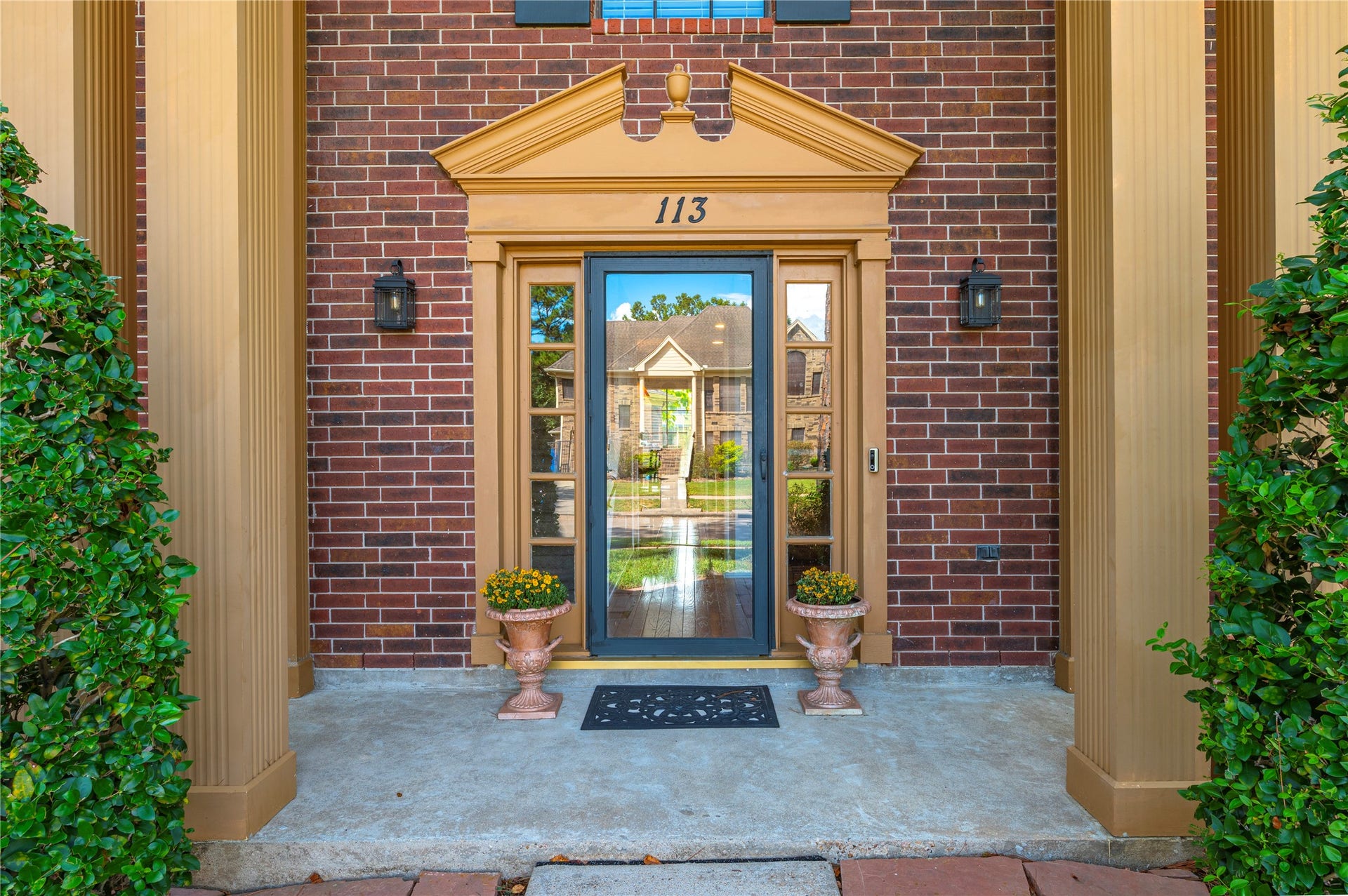 113 Coral Bay Drive, League City, TX 77573 A grand entry welcomes you home, featuring a beautiful front door with decorative sidelights, classic brick framing, and elegant architectural detail.
