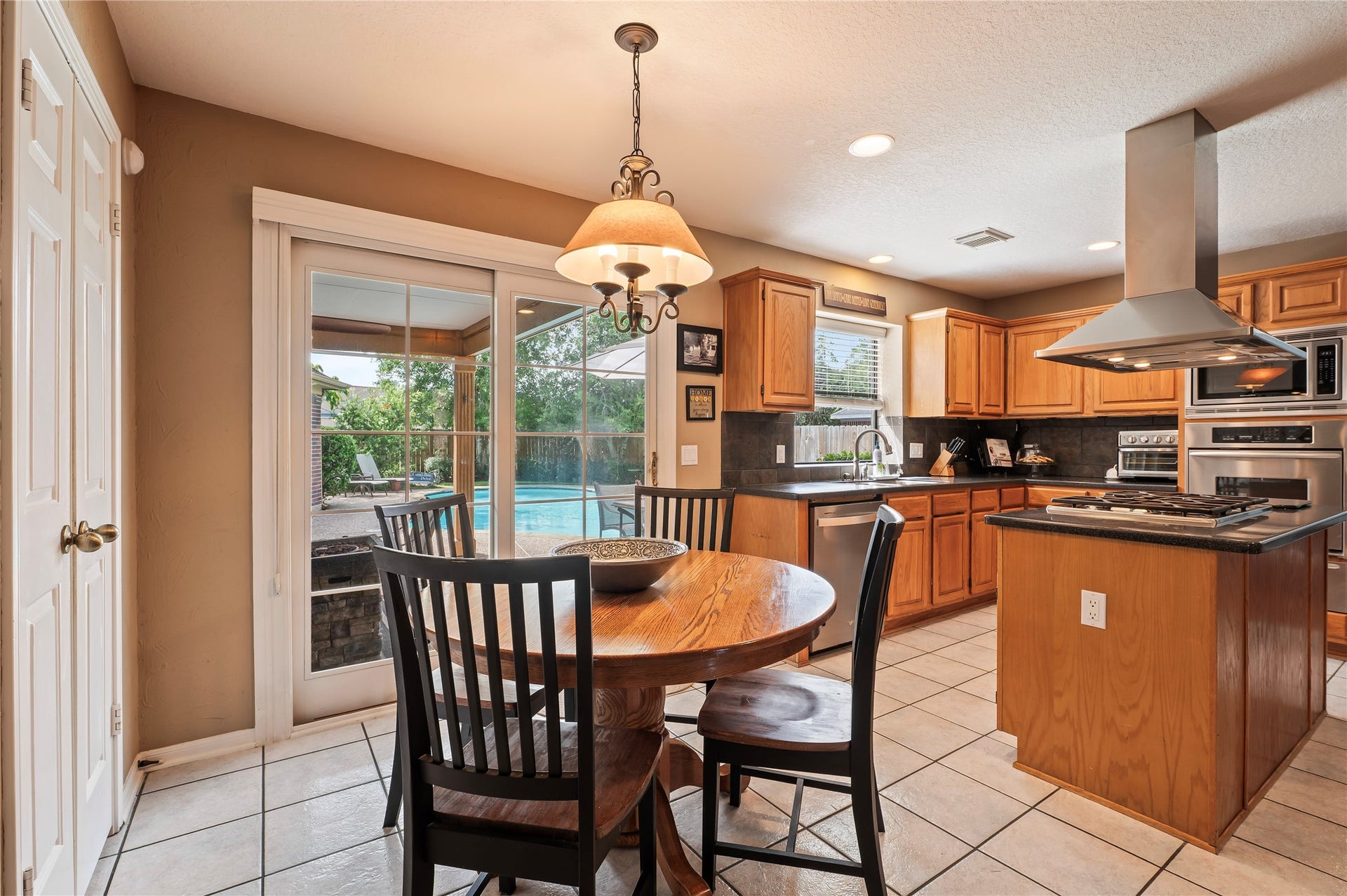 113 Coral Bay Drive, League City, TX 77573 The breakfast area has a sliding glass door with a retracting blind that opens to the covered patio. Wonderful when entertaining poolside!
