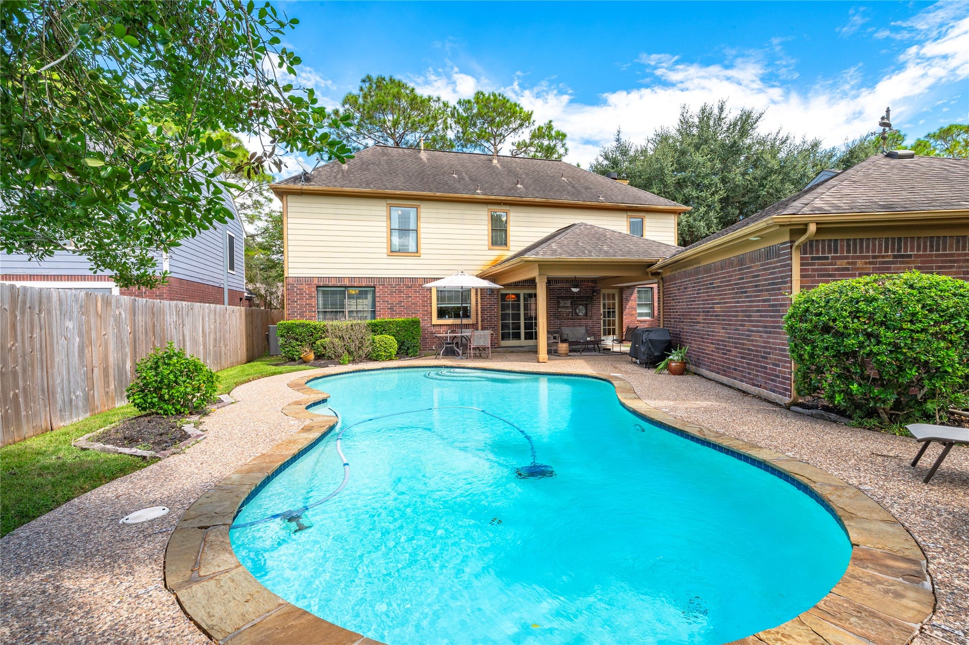 113 Coral Bay Drive, League City, TX 77573 The pool is surrounded by mature trees and a fully fenced backyard.