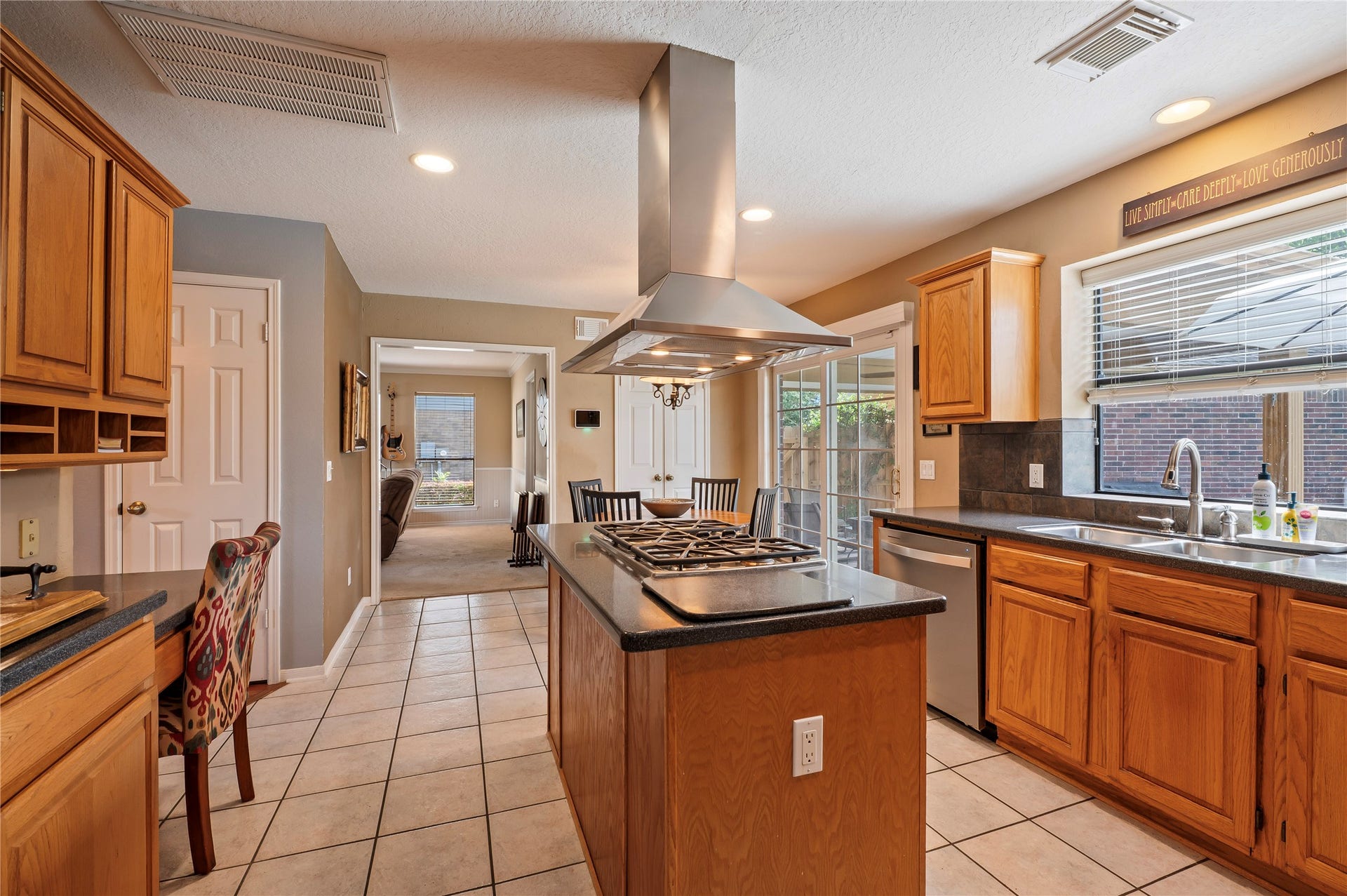 113 Coral Bay Drive, League City, TX 77573 The kitchen sits at the center of the home with an island, storage galore and a built-in desk with cubbies.