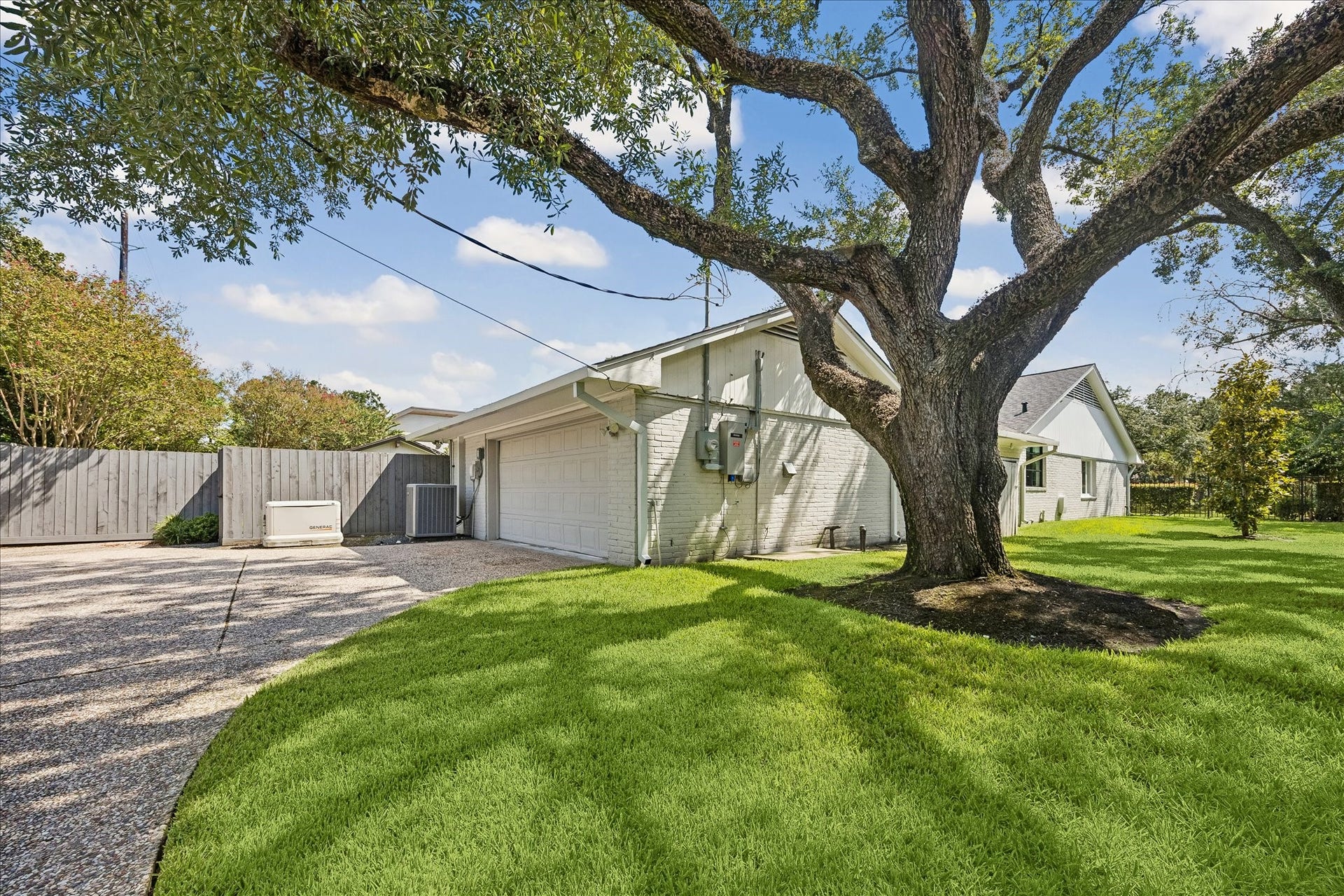 A whole-house generator provides added peace of mind. An automatic driveway gate leads to the two-car garage and additional parking, with a spacious side yard shaded by a beautiful mature tree.
