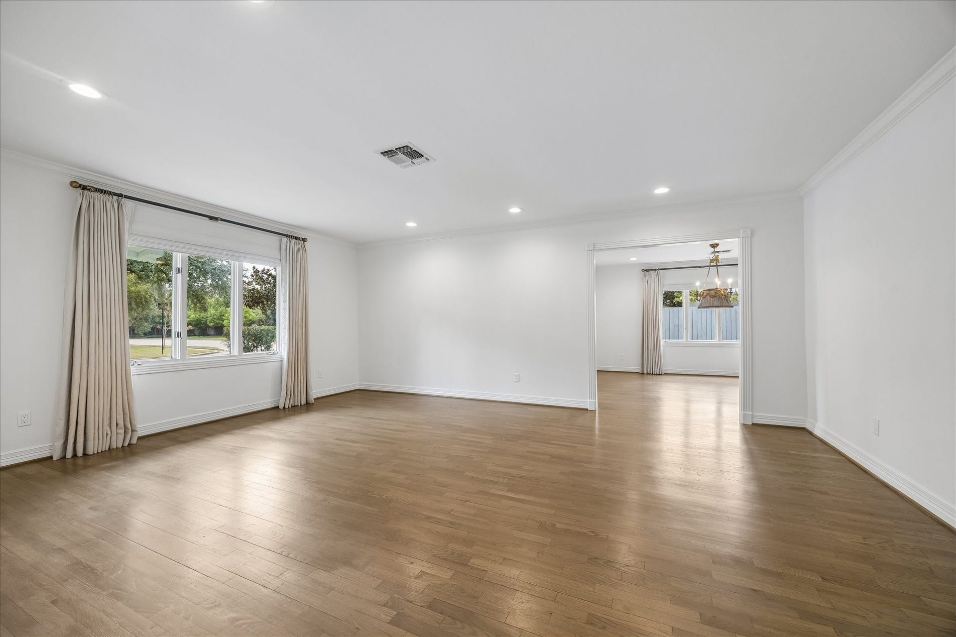 Just off the entry, the inviting formal living room features hardwood floors, tailored drapery and a graceful transition to the adjoining formal dining room.