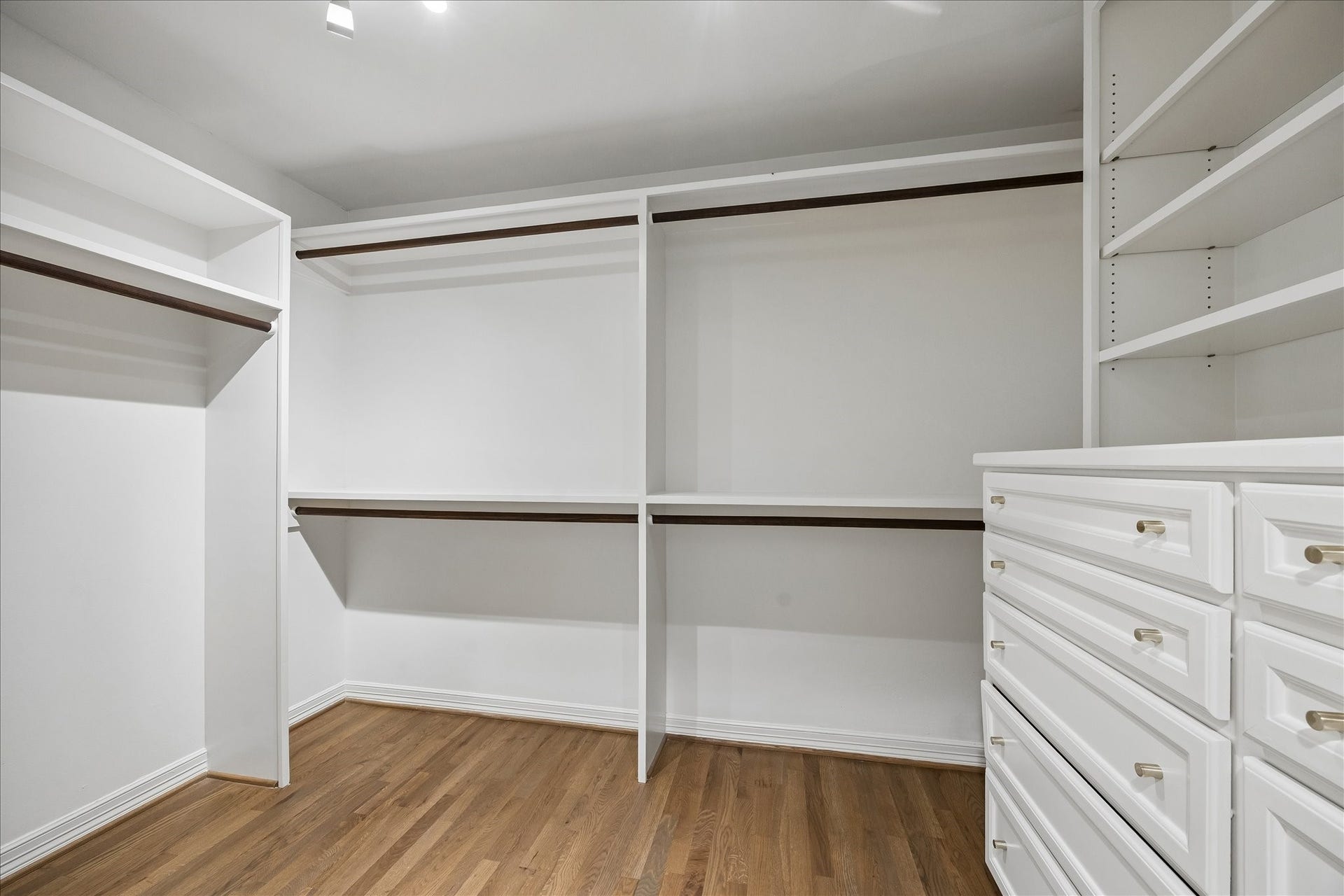 One of two generously sized walk-in closets in the primary suite, featuring extensive custom buit-ins.