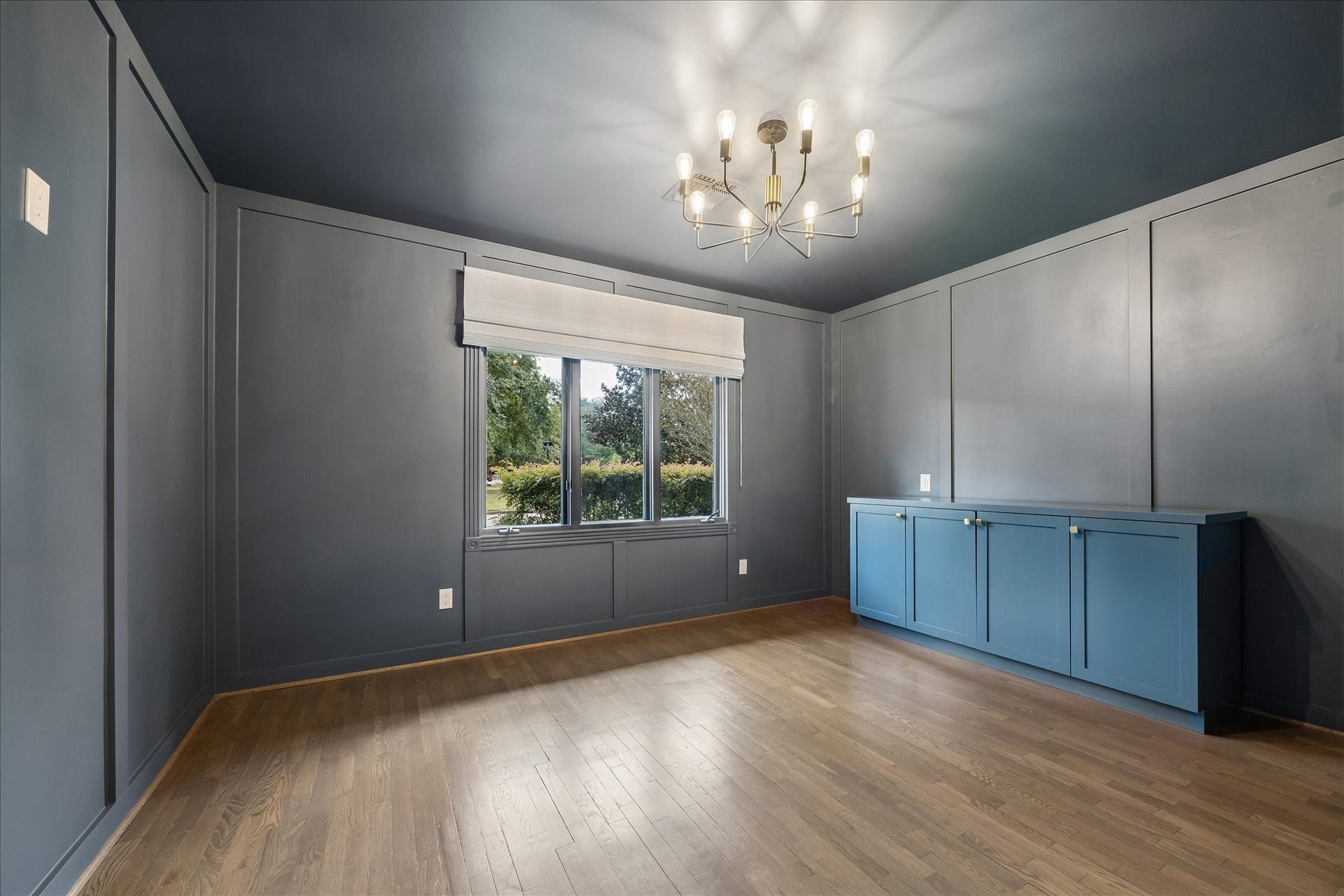Handsome home office with custom built-ins, paneled walls and designer lighting.