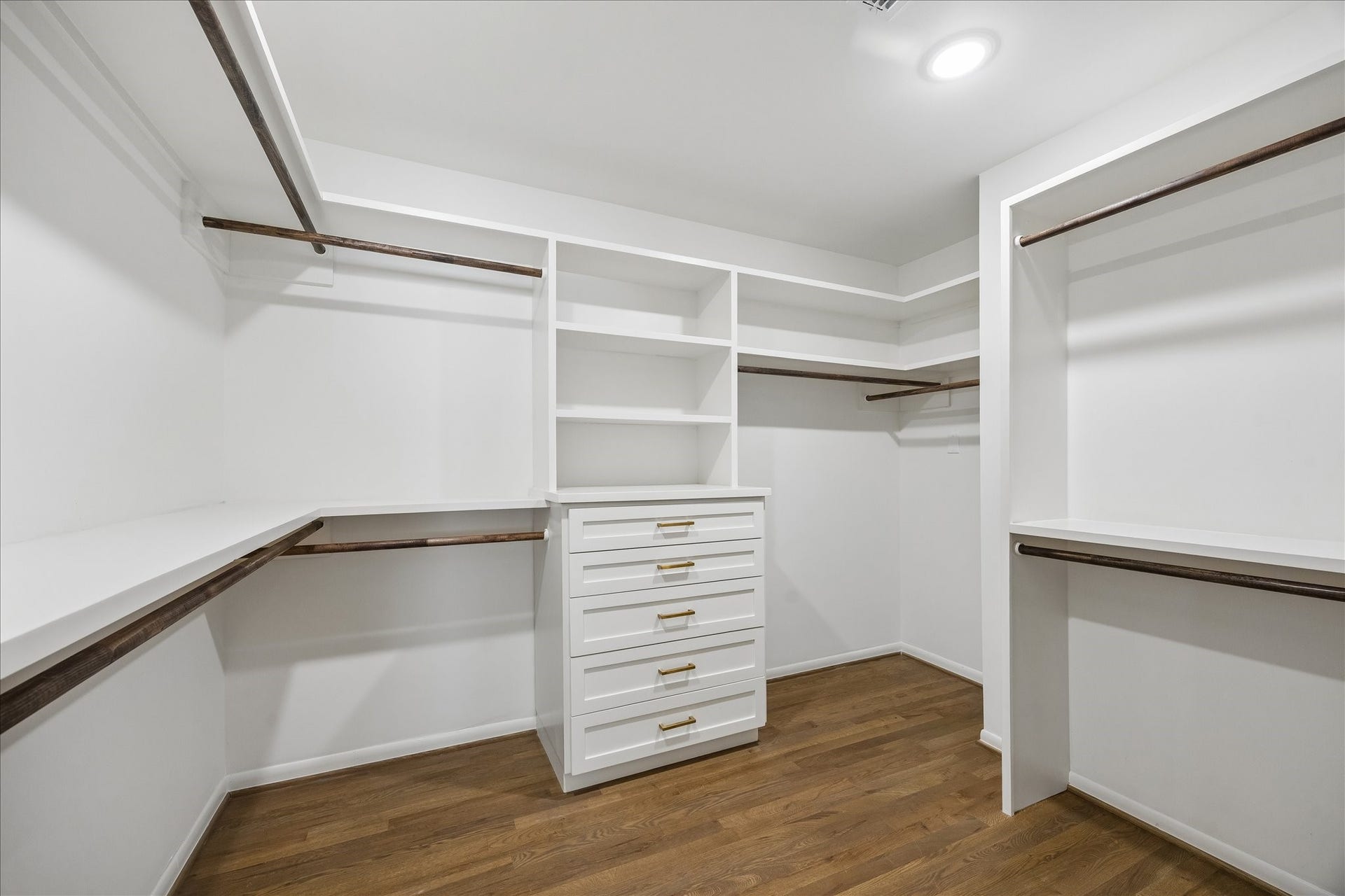 Spacious walk-in closet with shelving, drawers and an abundance of hanging space.