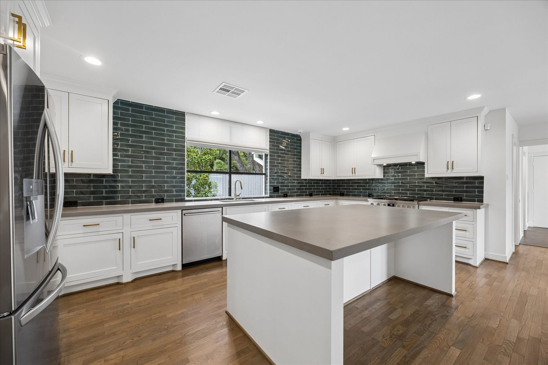 Quartz countertops and a generous center island with seating create a space designed for both everyday living and entertaining.