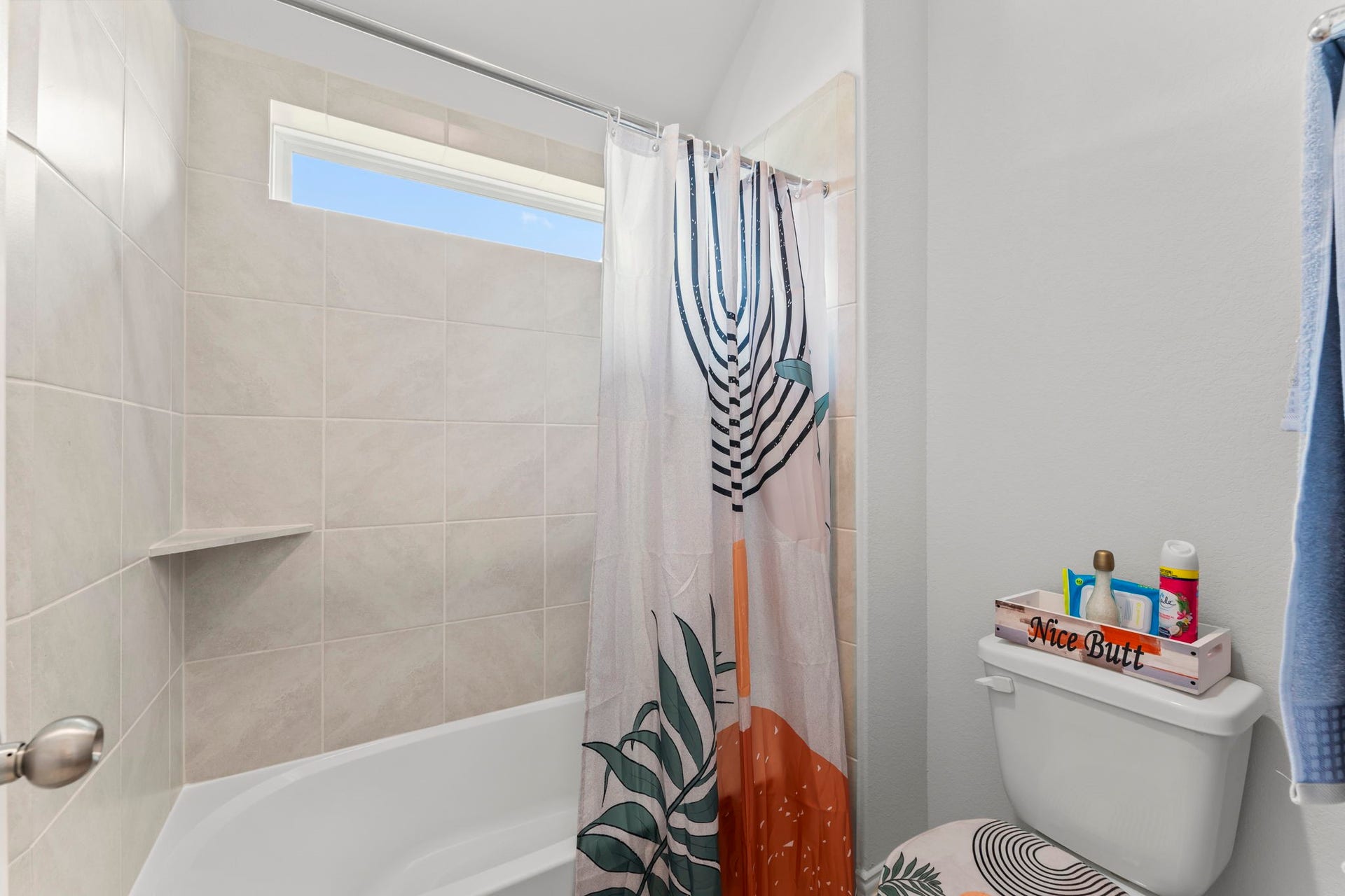 7054 Terra Drive, Manvel, TX 77578 Full bath with tiled shower/tub combo and a high transom window for natural light.