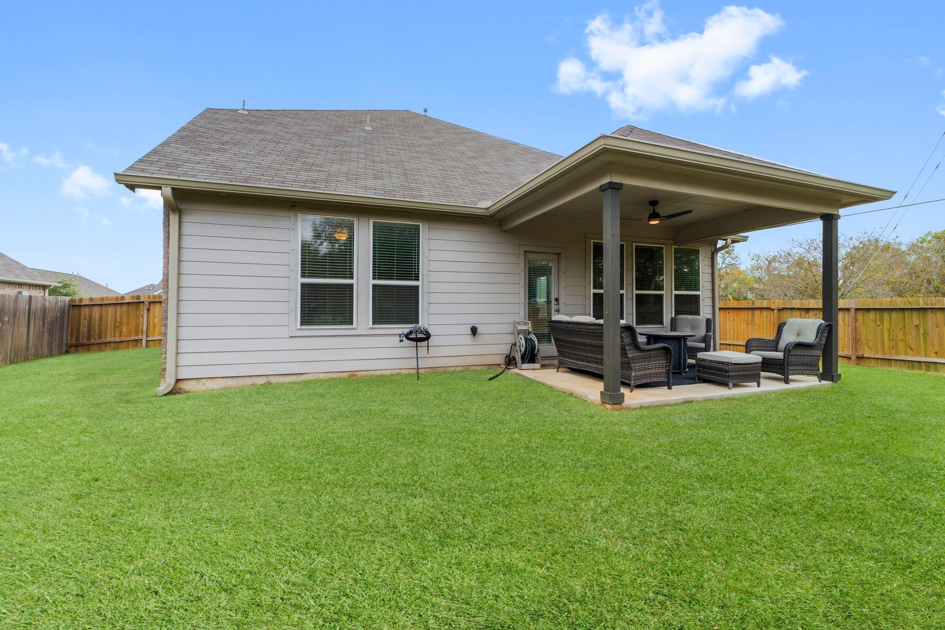 7054 Terra Drive, Manvel, TX 77578 Well-maintained yard with a spacious covered patio and mature trees nearby.