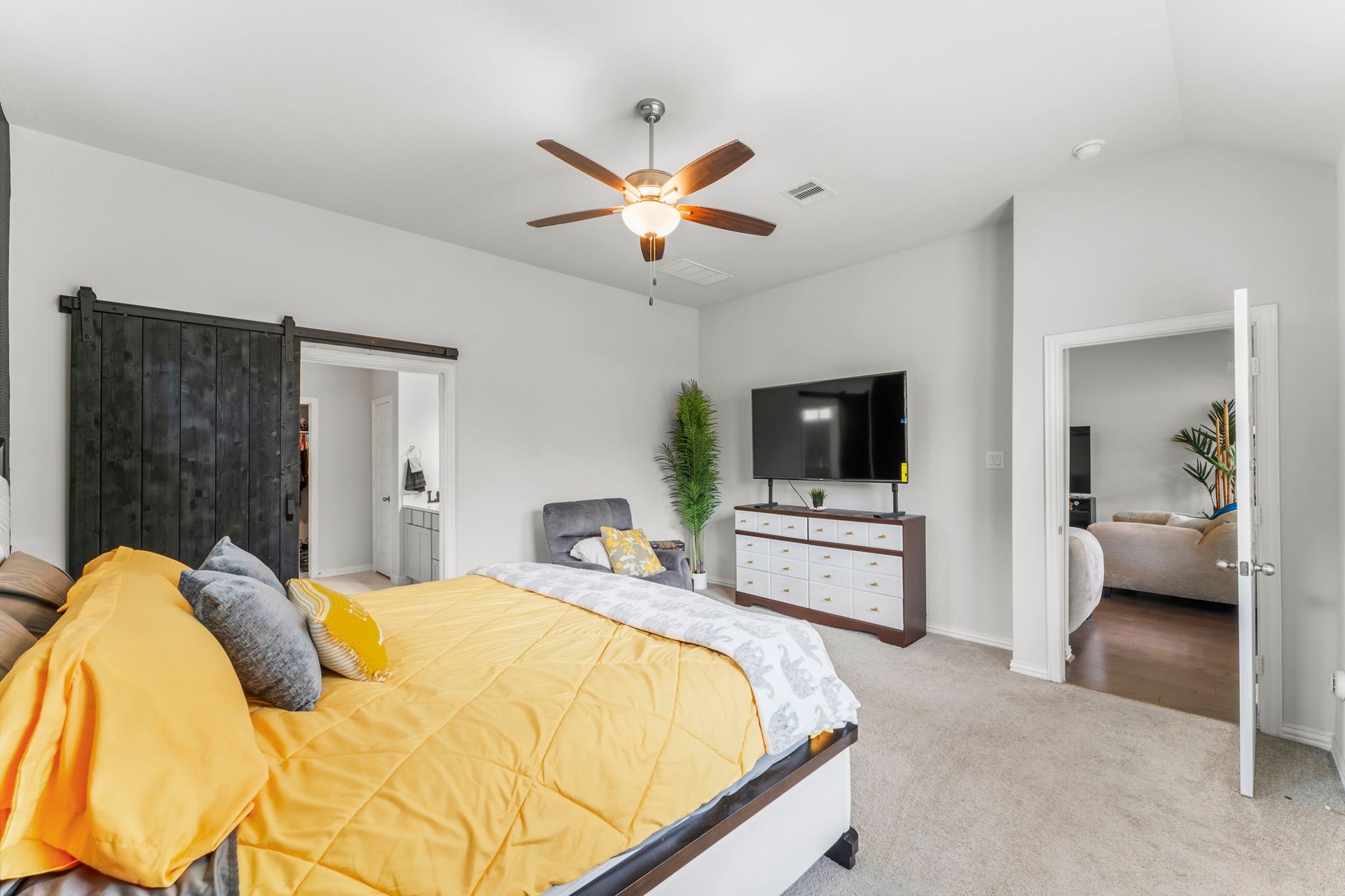 7054 Terra Drive, Manvel, TX 77578 Primary bedroom featuring a barn-door entry to the ensuite and walk-in closet.