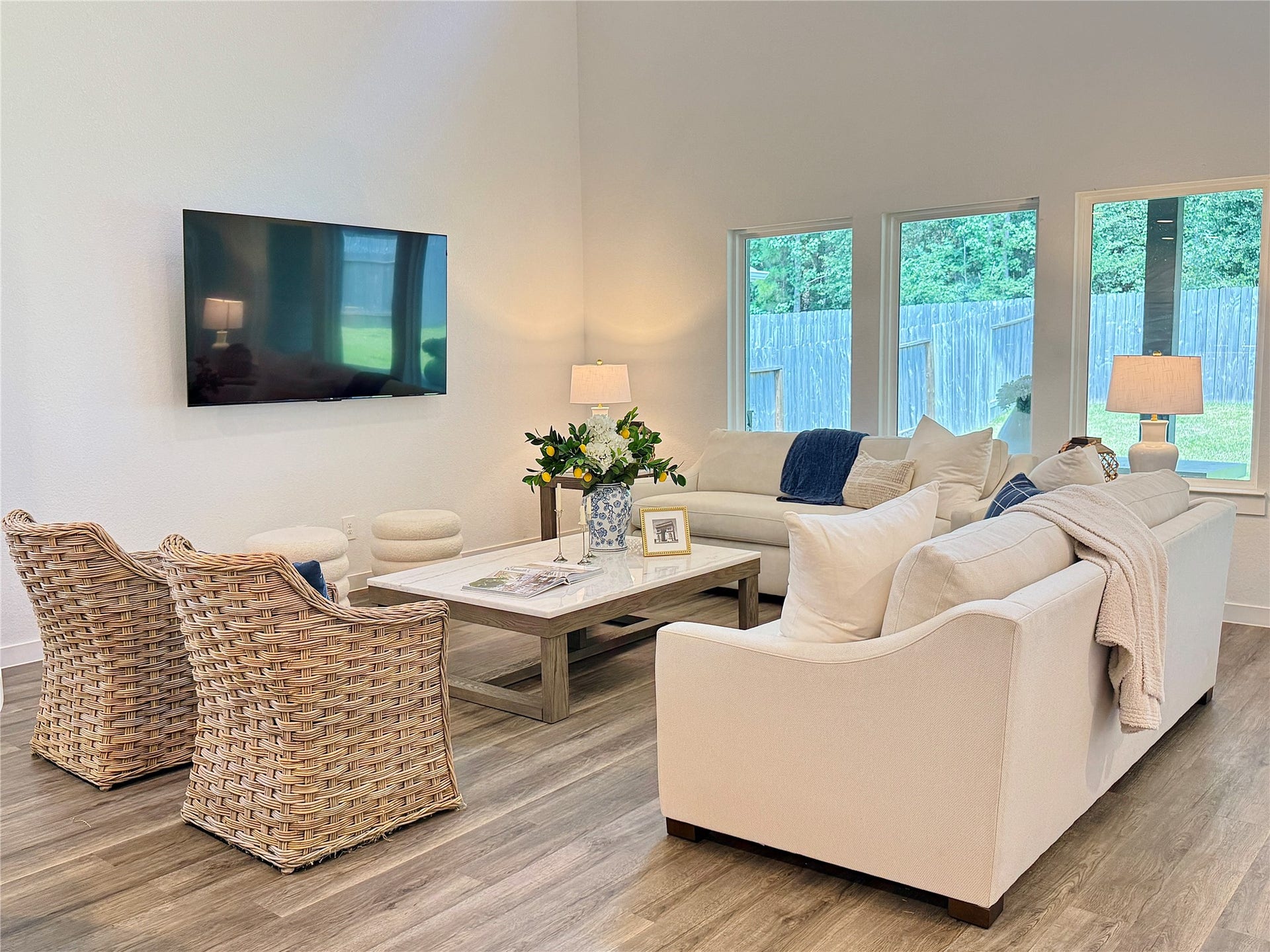 Spacious living room with abundant natural light from expansive windows overlooking the backyard.