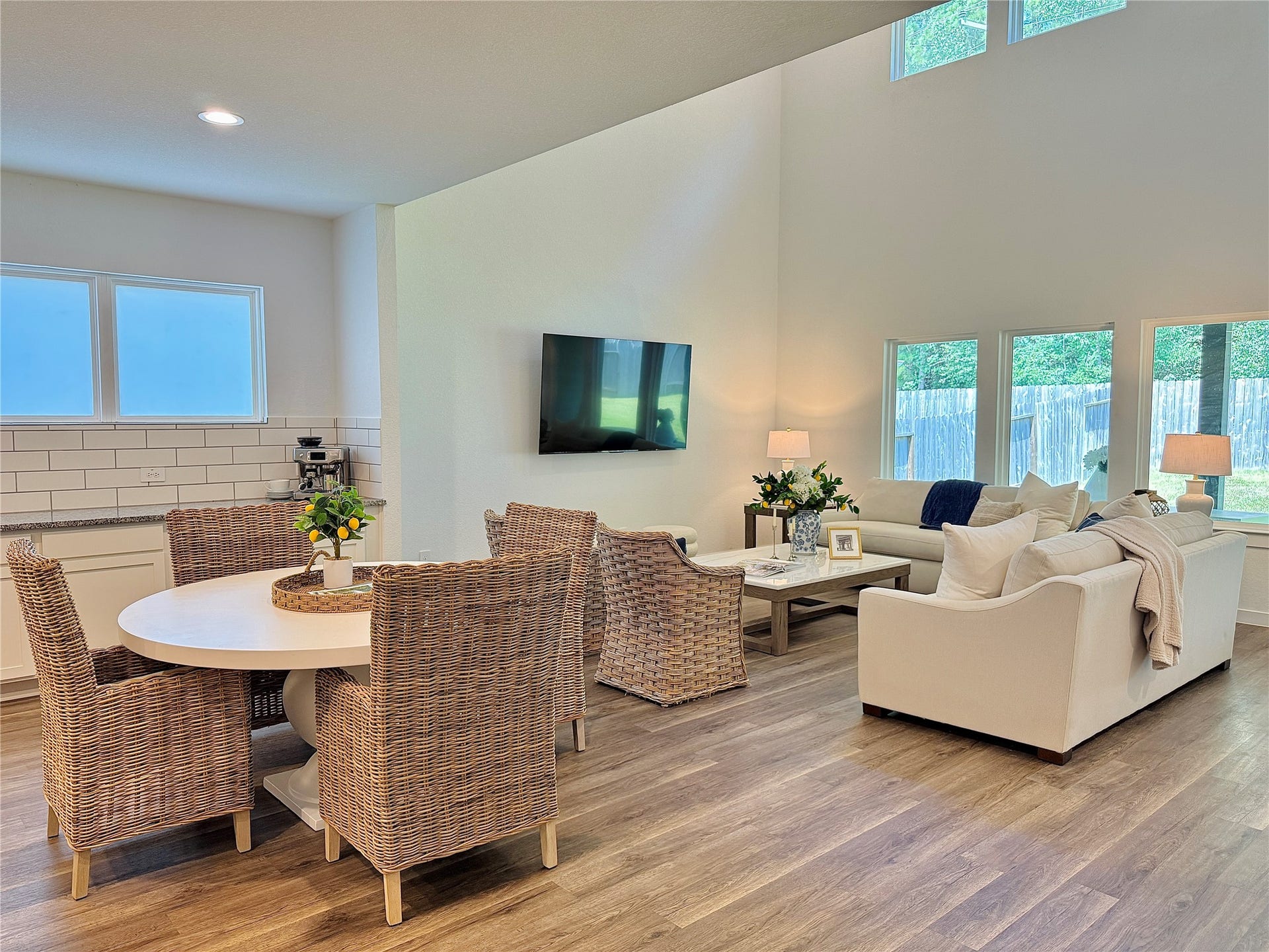 Bright and open living space with high ceilings, featuring a cozy dining area with large windows
