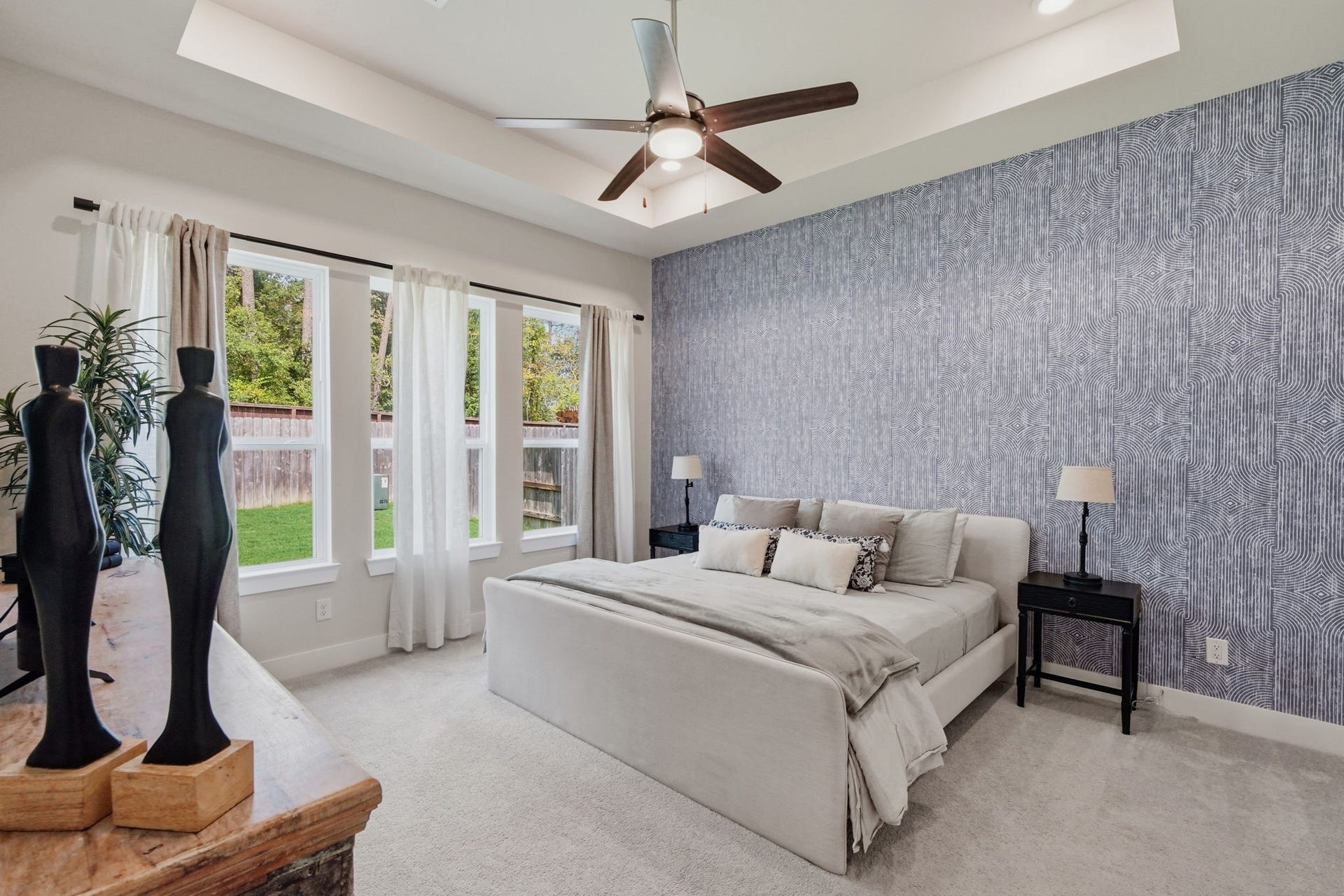 24615 Lukes Landing Way, Tomball, TX 77375 Spacious Primary bedroom with a stylish accent wall, abundant natural light from large windows, and a cozy atmosphere perfect for relaxation.