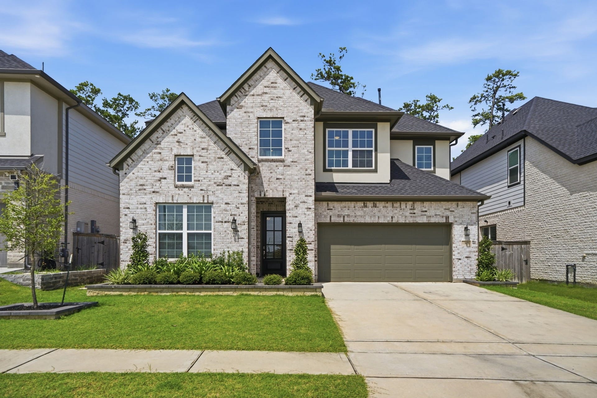 24615 Lukes Landing Way, Tomball, TX 77375 Stunning two-story brick home with modern architecture, featuring a spacious driveway and lush landscaping, offering great curb appeal in a serene neighborhood.