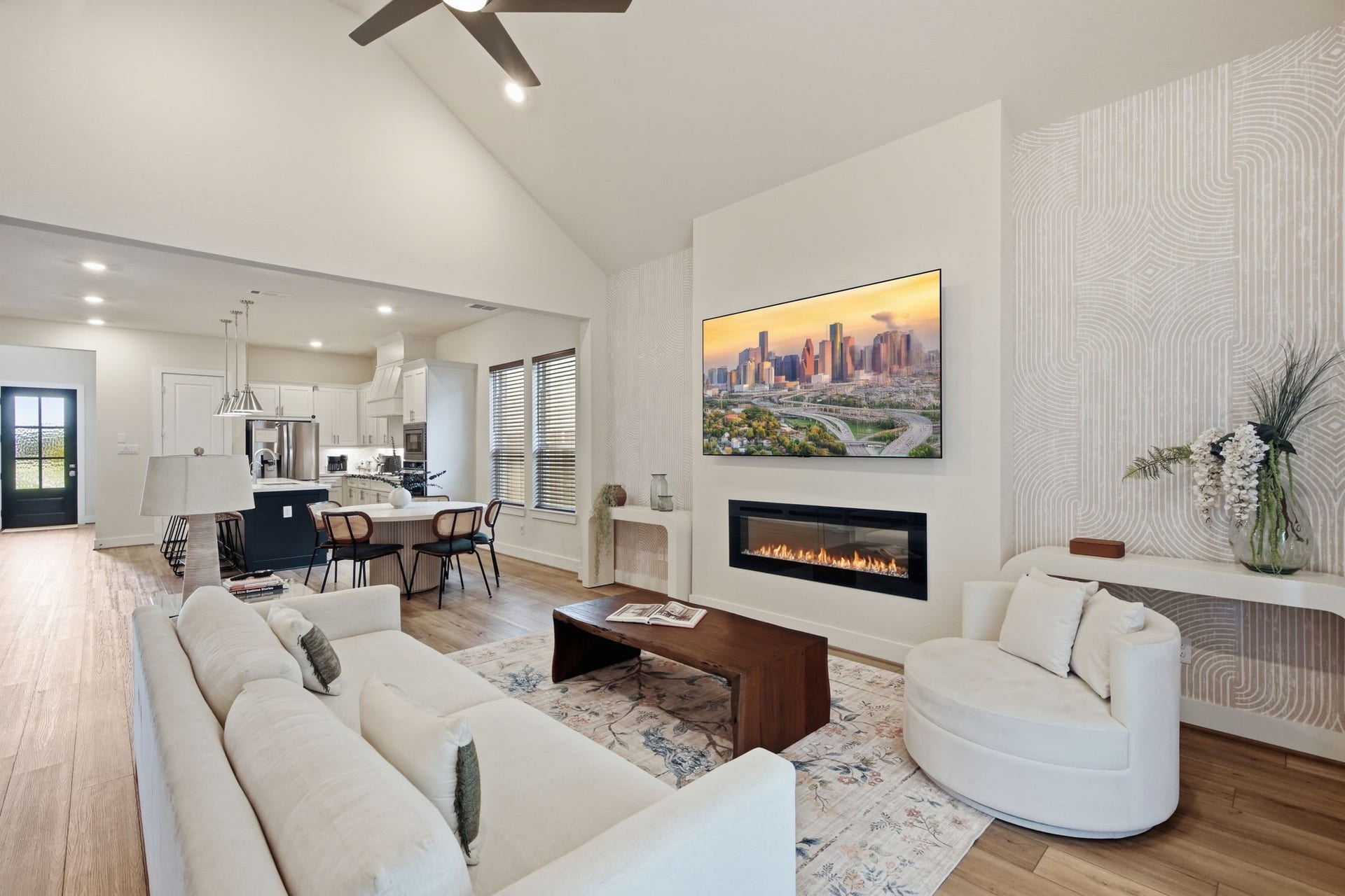 24615 Lukes Landing Way, Tomball, TX 77375 Spacious and inviting living area features a modern fireplace, elegant decor, and an open layout leading into a bright, contemporary kitchen.